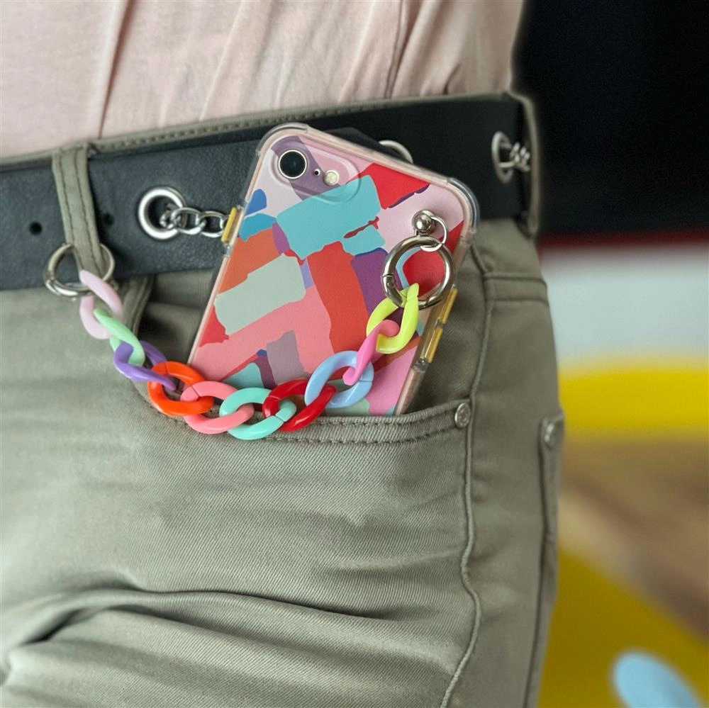 Uno smartphone con cover colorata e catena in plastica in tasca.