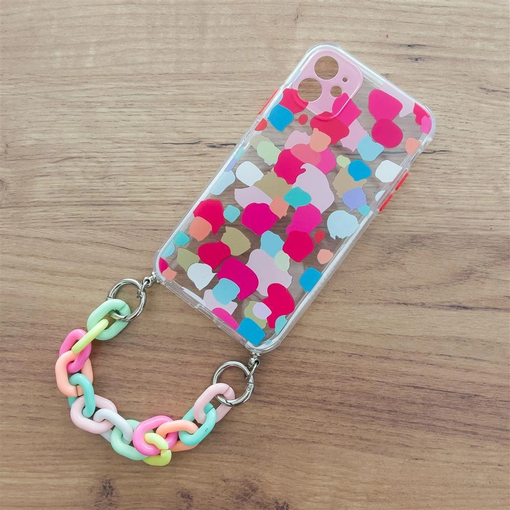Custodia trasparente per telefono con macchie colorate e catena in plastica pastello su tavolo.