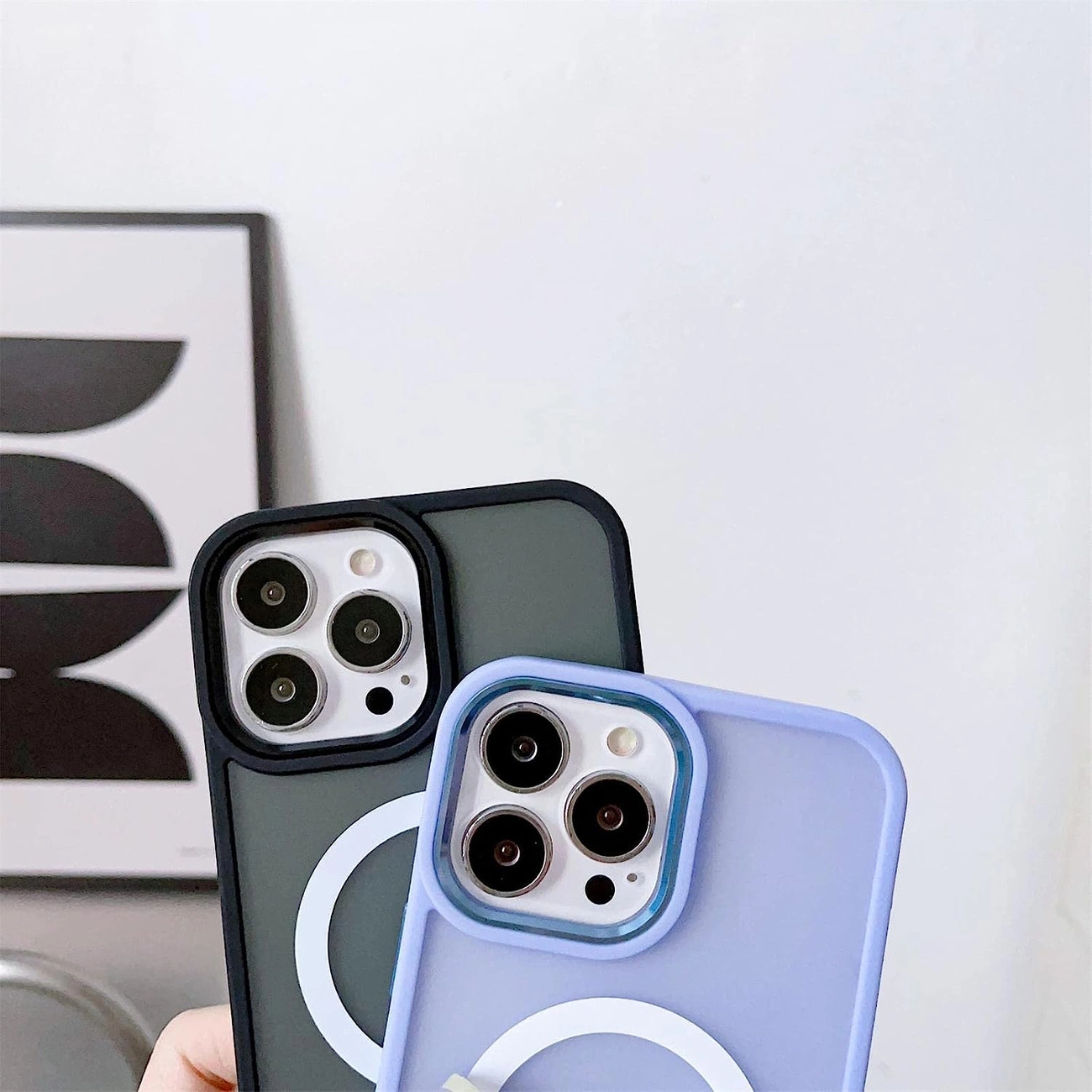 Due smartphone in custodia scura e azzurra con moduli fotocamera circolari su sfondo chiaro.