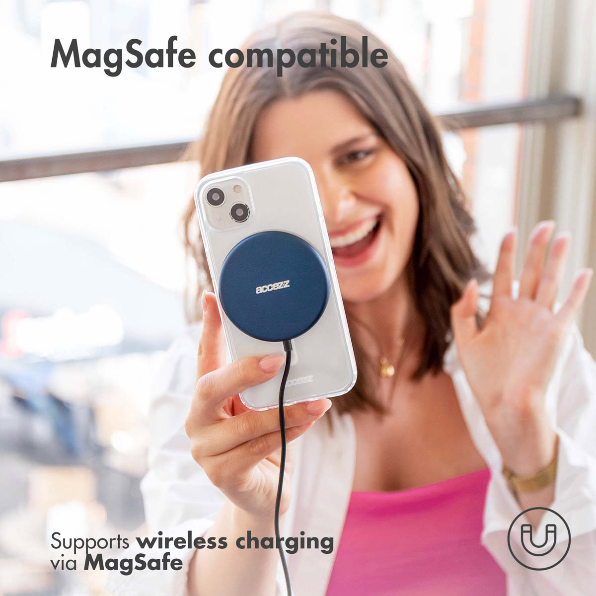 Una mujer sostiene un teléfono con un cargador MagSafe.