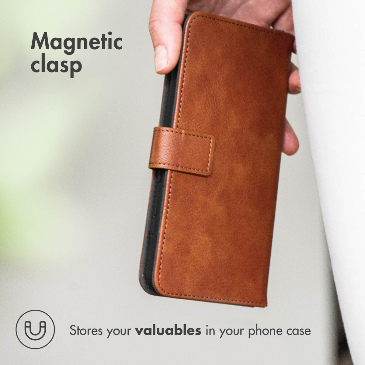 Mano tiene una custodia in pelle marrone per telefono con chiusura magnetica.