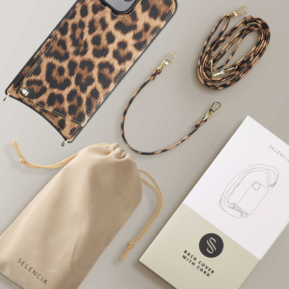 Funda de móvil con estampado de leopardo, dos correas, bolsa y caja sobre fondo gris.