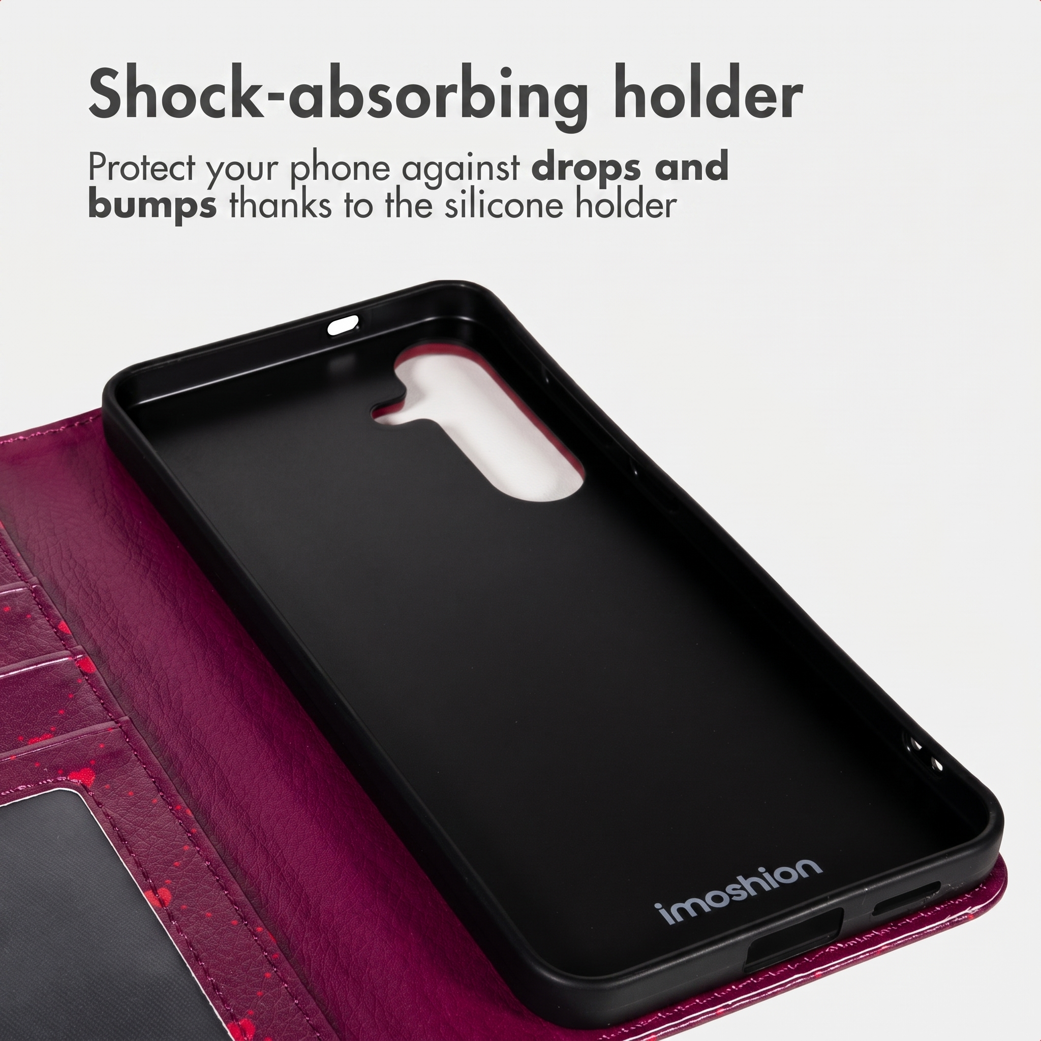 Een roze telefoonhoesje met zwarte siliconen houder en tekst boven.