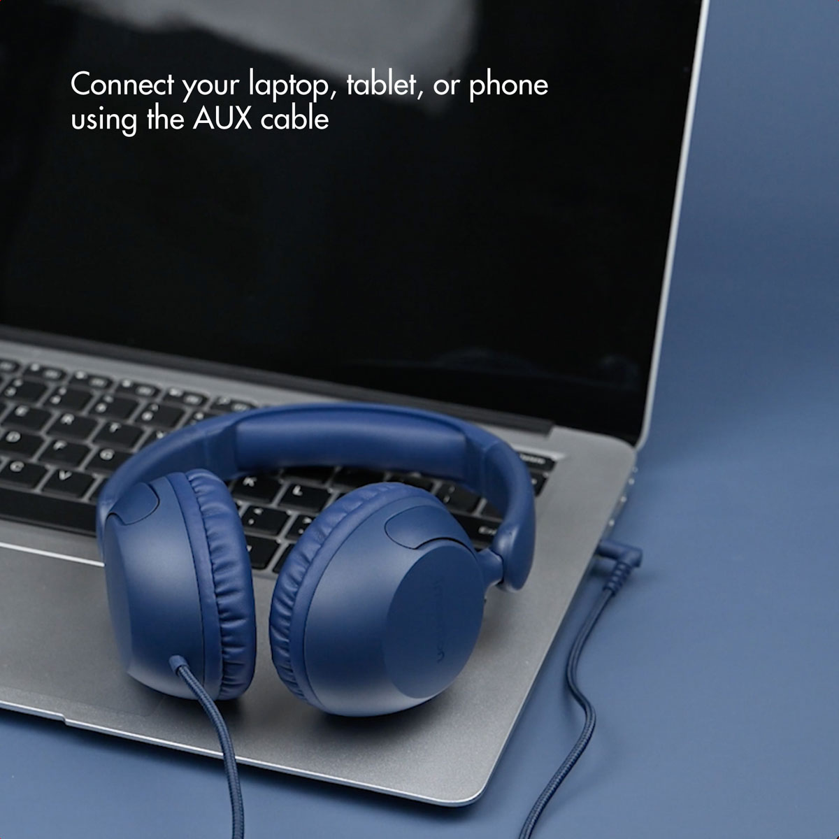 Auriculares azules en el teclado de una computadora portátil con texto sobre conectar dispositivos.