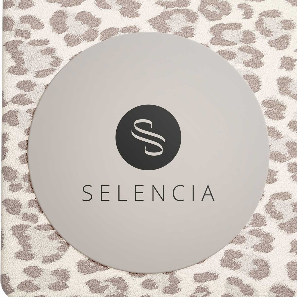 Una tarjeta gris redonda con el logotipo de SELENCIA presenta una S estilizada, sobre un fondo con estampado de leopardo marrón.