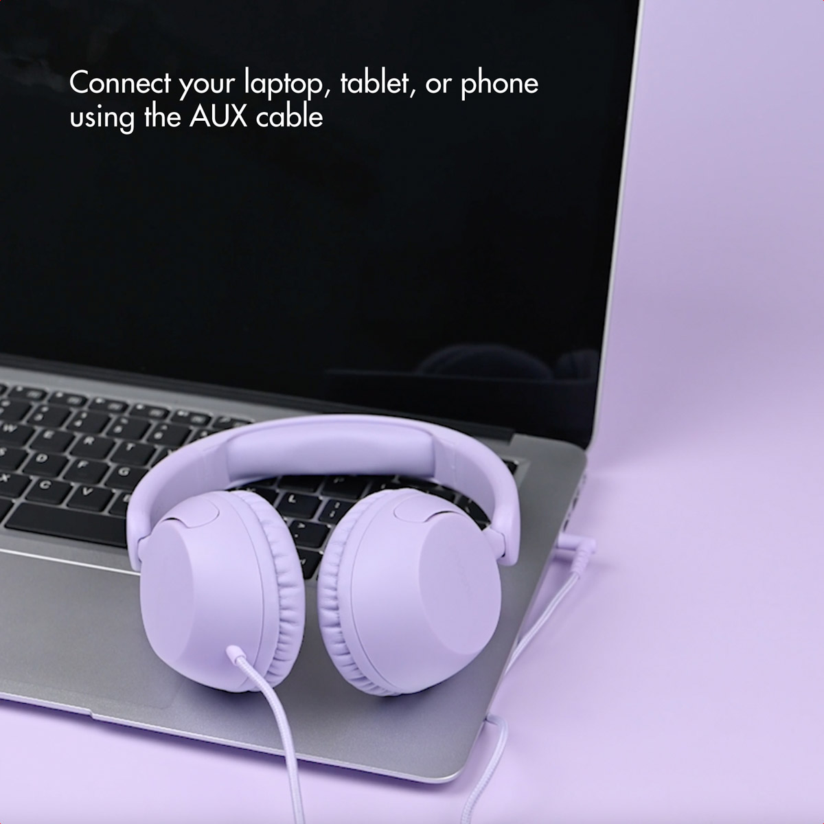 Auriculares morados en el teclado de un portátil con texto en pantalla sobre fondo morado.