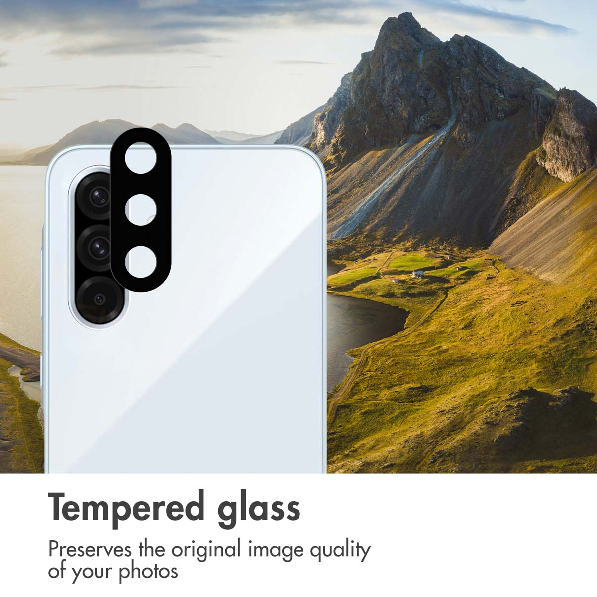 Smartphone bianco con modulo fotocamera nero davanti a un paesaggio montano con lago.