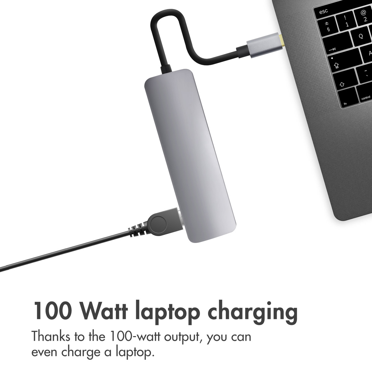 Ein grauer USB-C-Hub am Laptop mit angeschlossenem Kabel und Text über 100-Watt-Laptop-Laden unten.