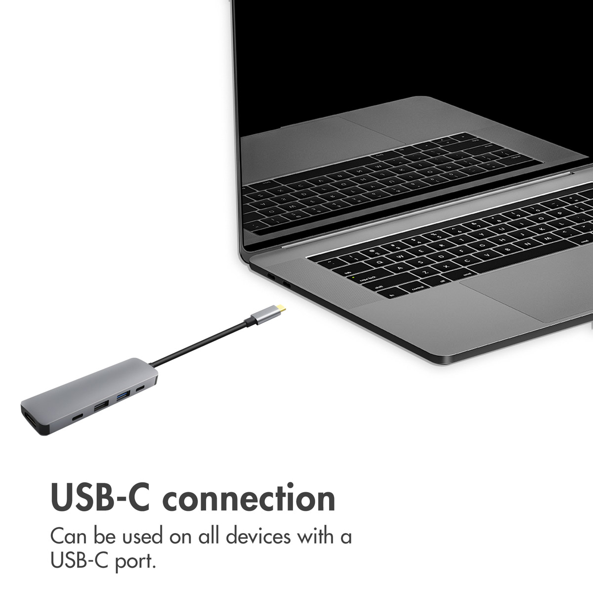 Ein grauer USB-C-Hub mit Kabel liegt neben einem silbernen Laptop. Text: USB-C connection.