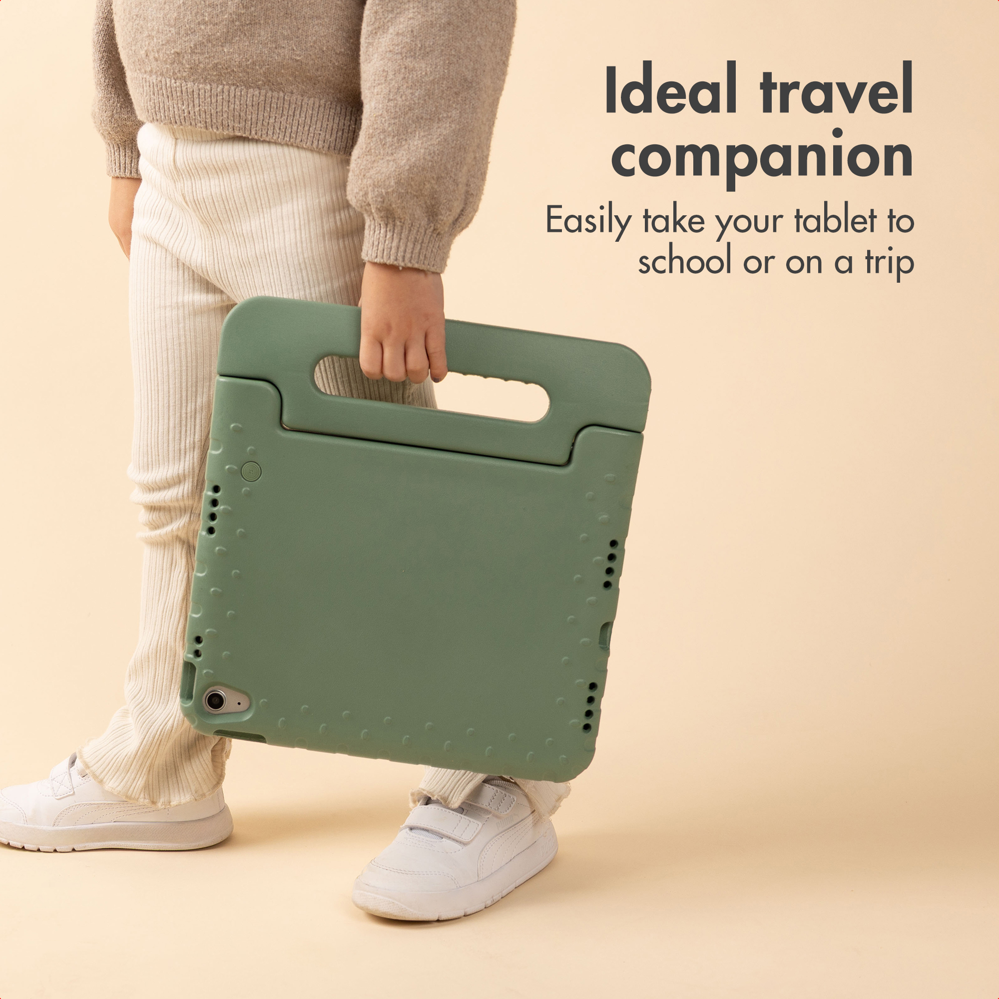 Un enfant tient une coque de protection verte avec poignée sur fond beige, avec du texte publicitaire.