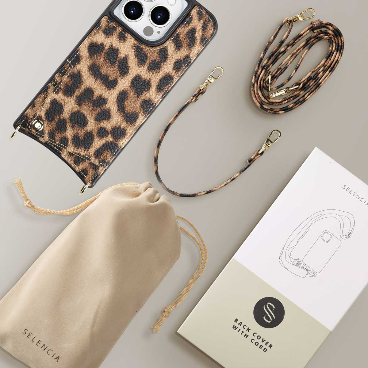 Fundá de teléfono con estampado de leopardo, correa, bolsa y caja sobre fondo beige.