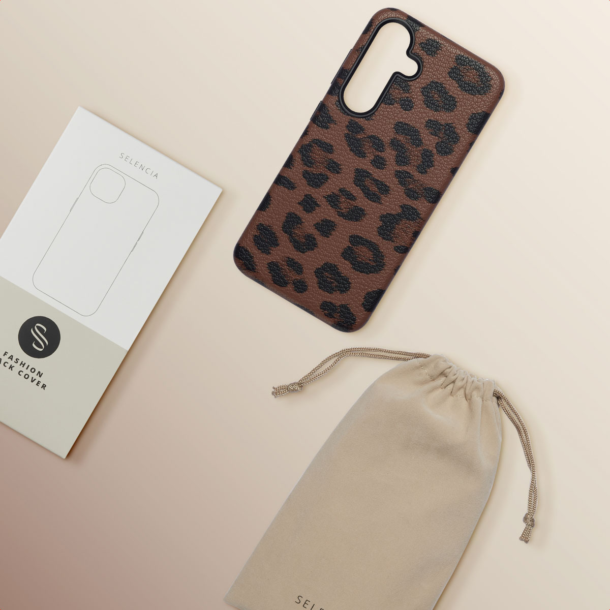 Una funda de móvil con estampado de leopardo, su caja y una bolsa beige yacen sobre una superficie clara.