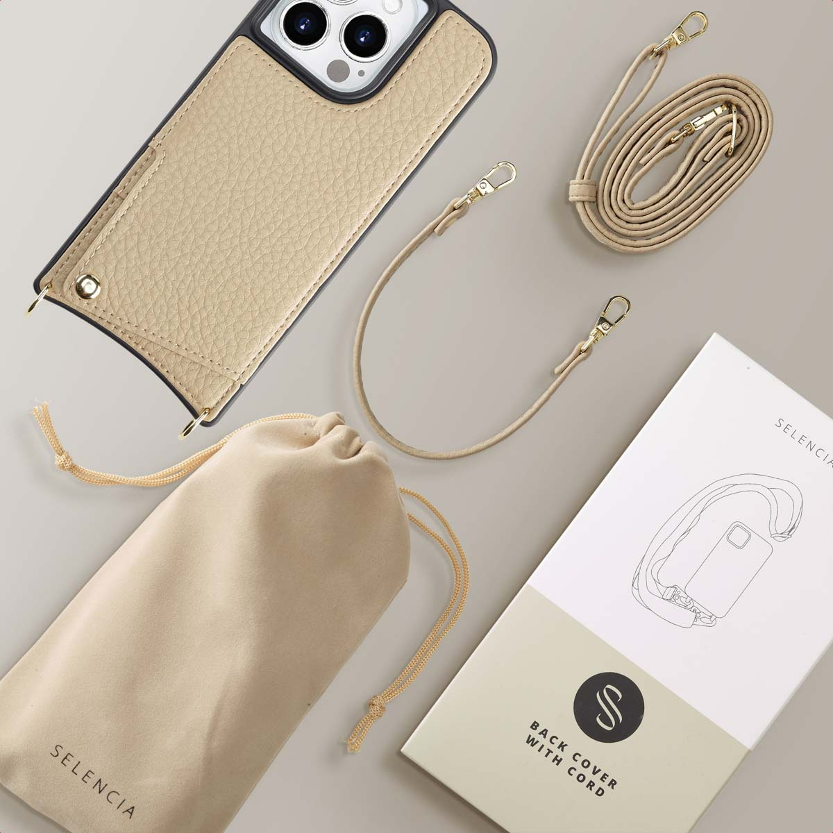 Funda de teléfono beige con correa, bolsa y caja de producto sobre fondo claro.
