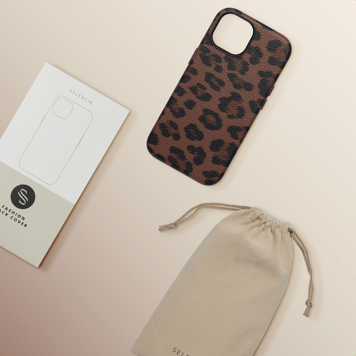 Cover per cellulare leopardata accanto a scatola e sacchetto di stoffa su sfondo chiaro.