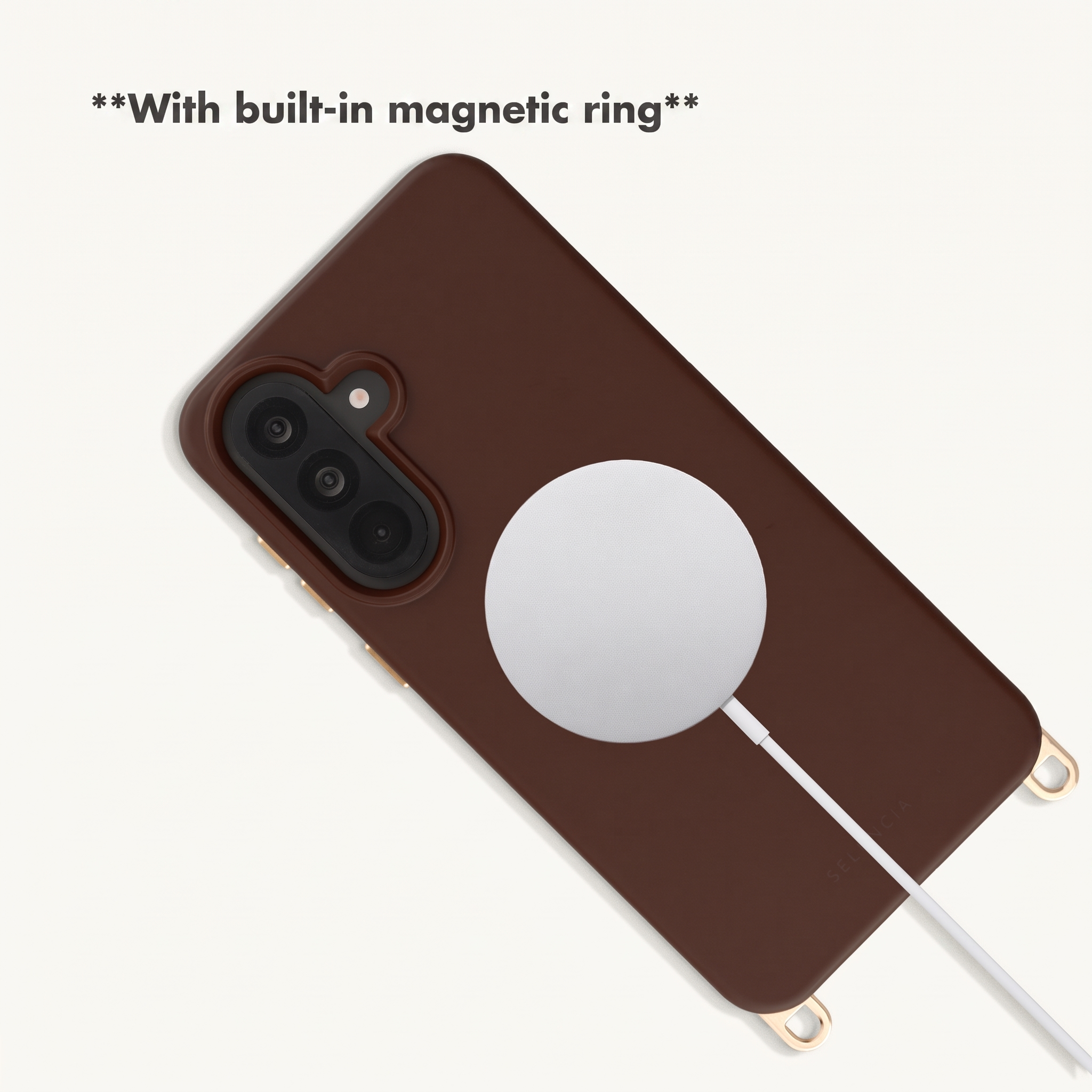 Braune Smartphone-Hülle mit magnetischem Ring und weißem Ladekabel auf hellem Hintergrund.