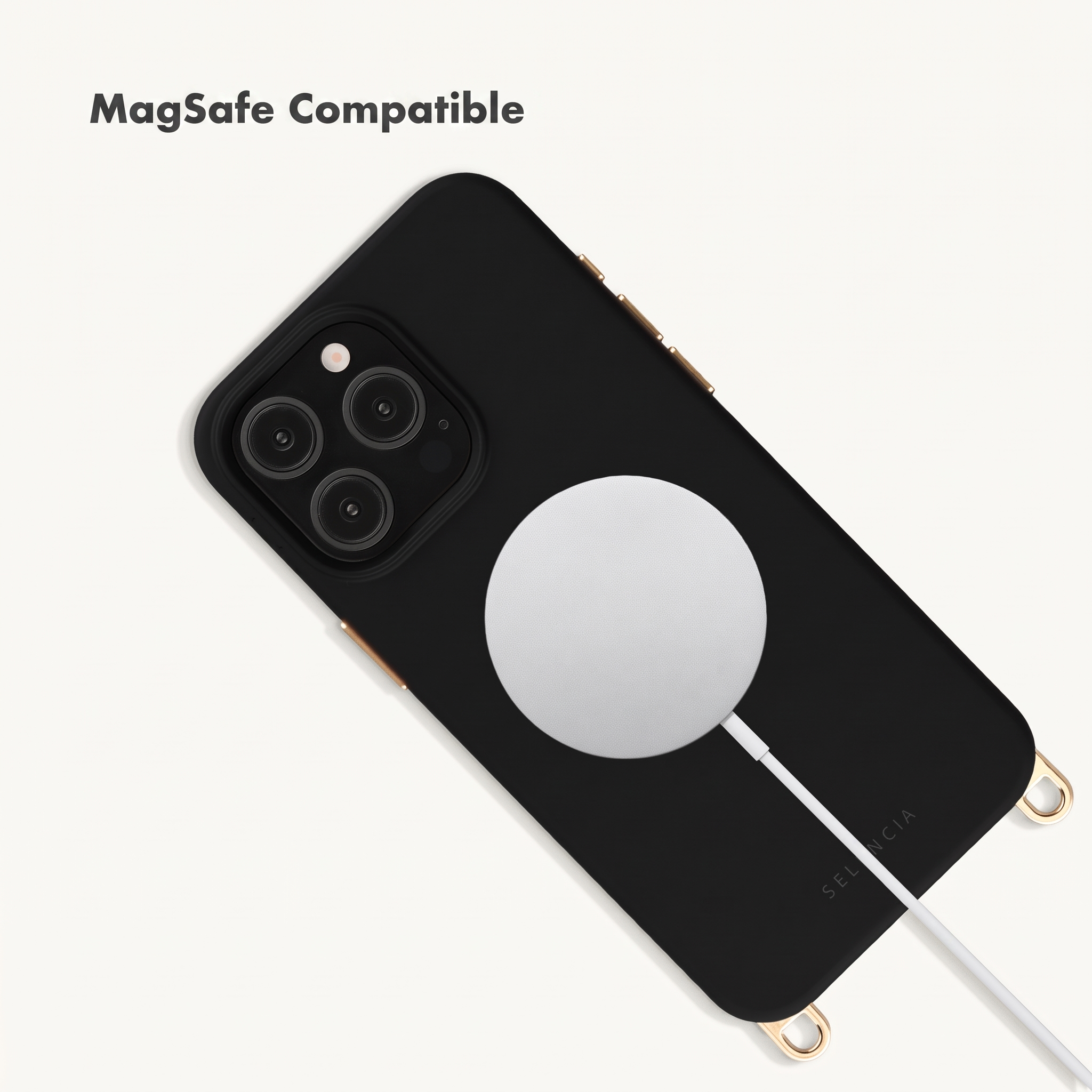 Ein schwarzes Smartphone mit einer weißen runden MagSafe-Ladestation und goldenen Akzenten auf weißem Hintergrund.