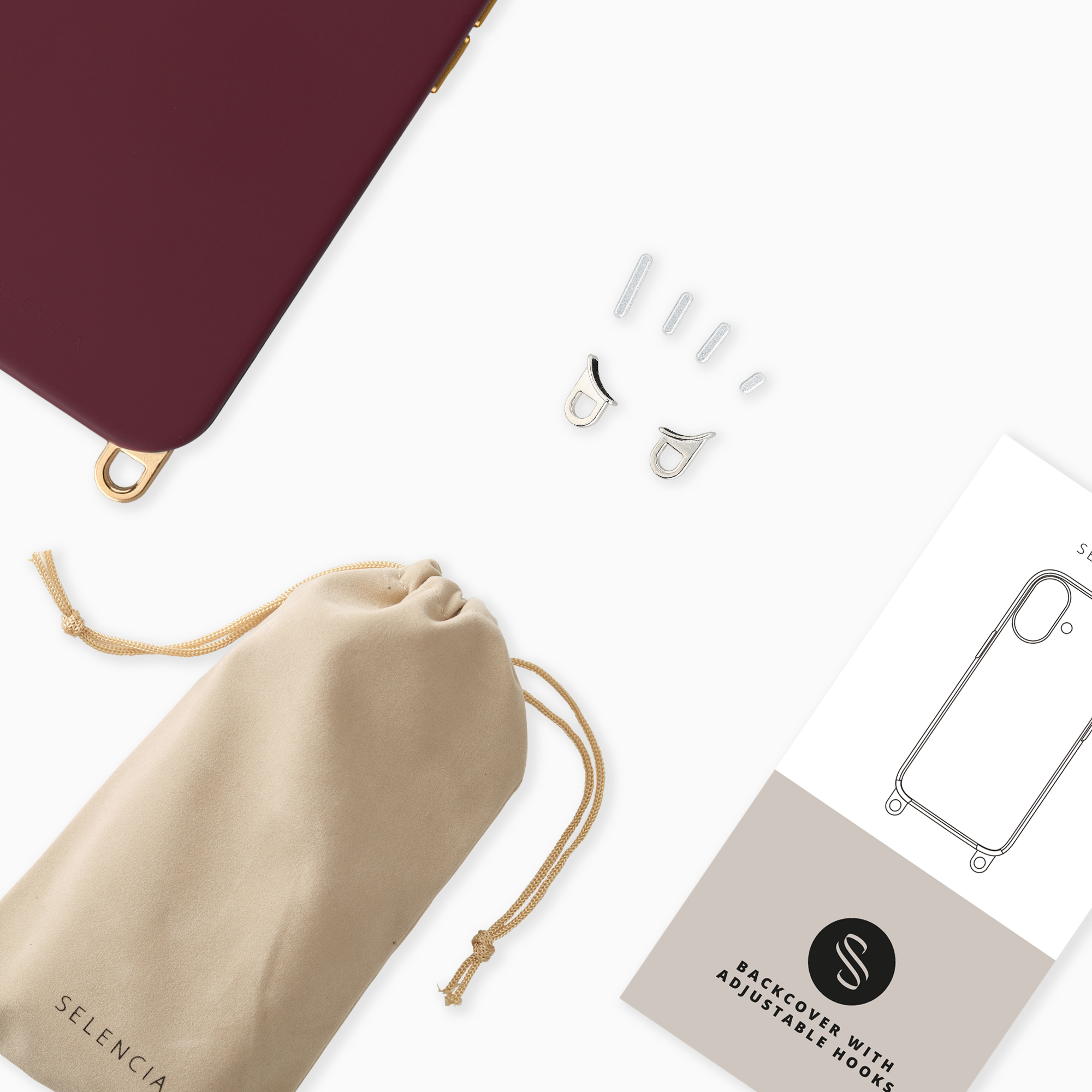 Coque de téléphone bordeaux, accessoires métalliques, pochon et notice sur fond blanc.