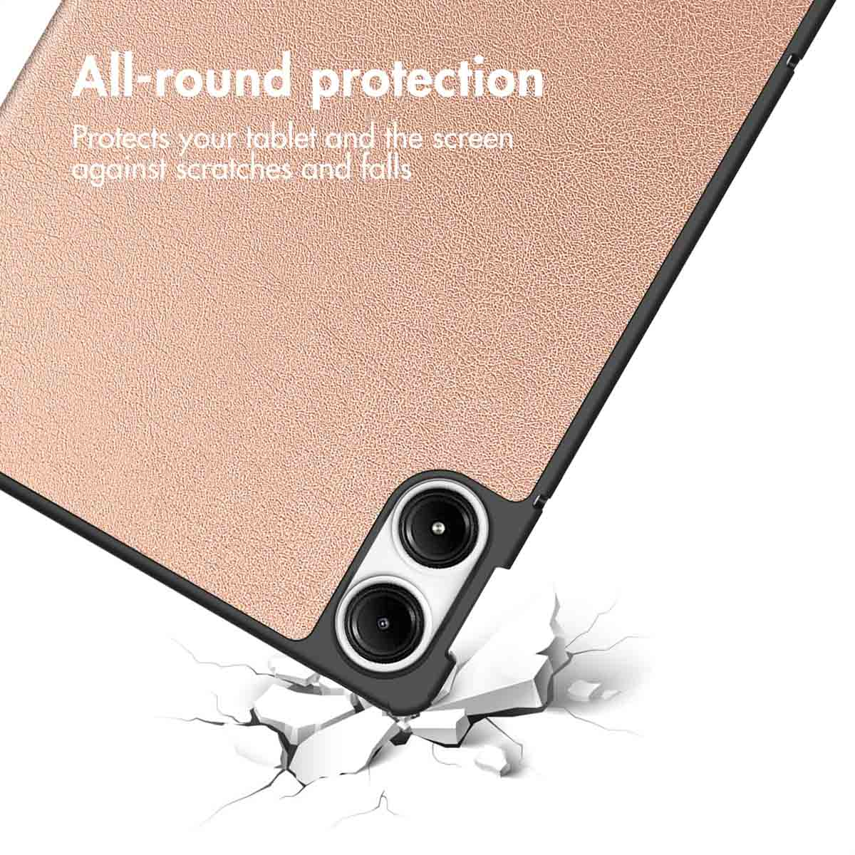 Roségouden tablet hoesje met twee cameralenzen, geplaatst op een gebarsten oppervlak.