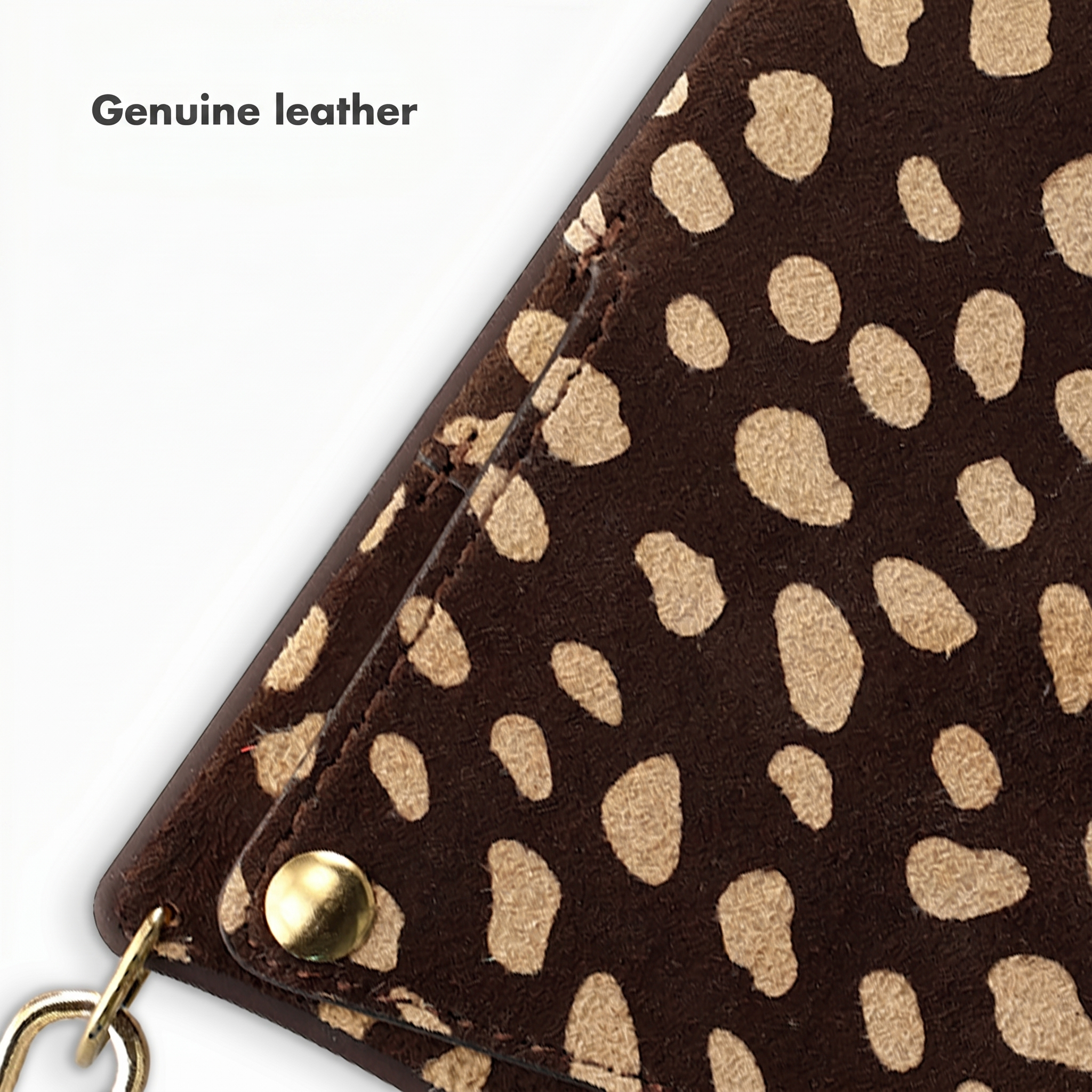 Gros plan sur un portefeuille en cuir marron avec motif animal beige, bouton-pression doré et breloque.