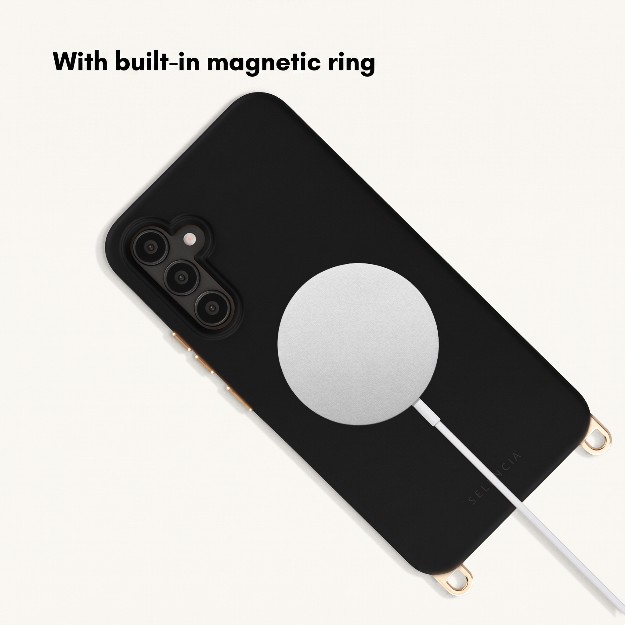Funda de teléfono negra con anillo magnético y cable de carga blanco sobre fondo beis.