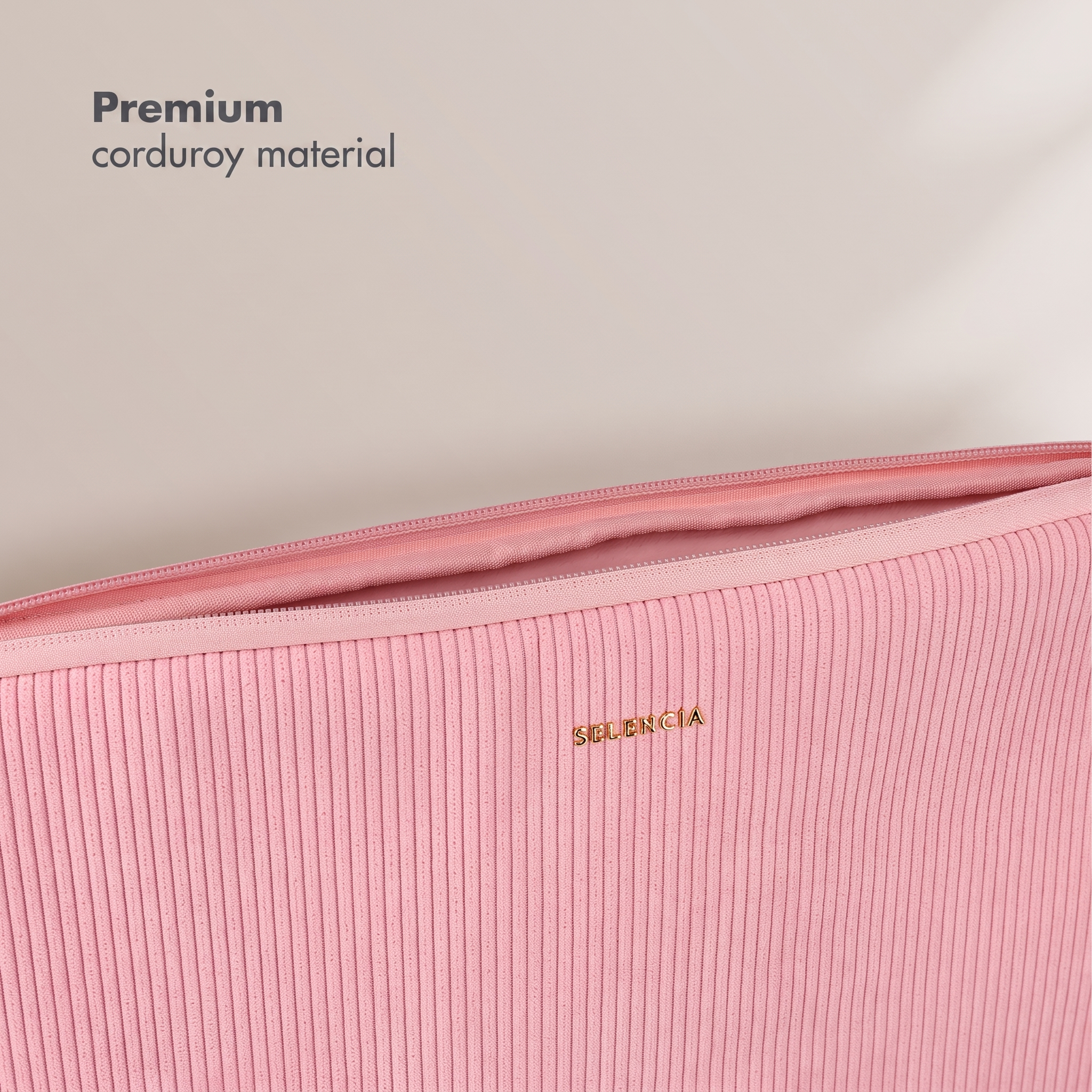 Eine rosa Kord-Laptop-Hülle mit goldener SELENCIA-Aufschrift vor hellgrauem Hintergrund.