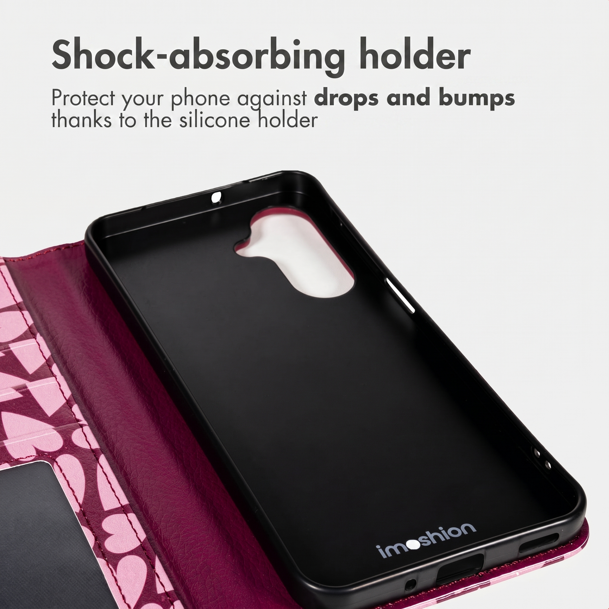 Roze telefoonhoesje met hartjesprint en zwarte siliconenhouder. Bovenste tekst: Shock-absorbing holder.