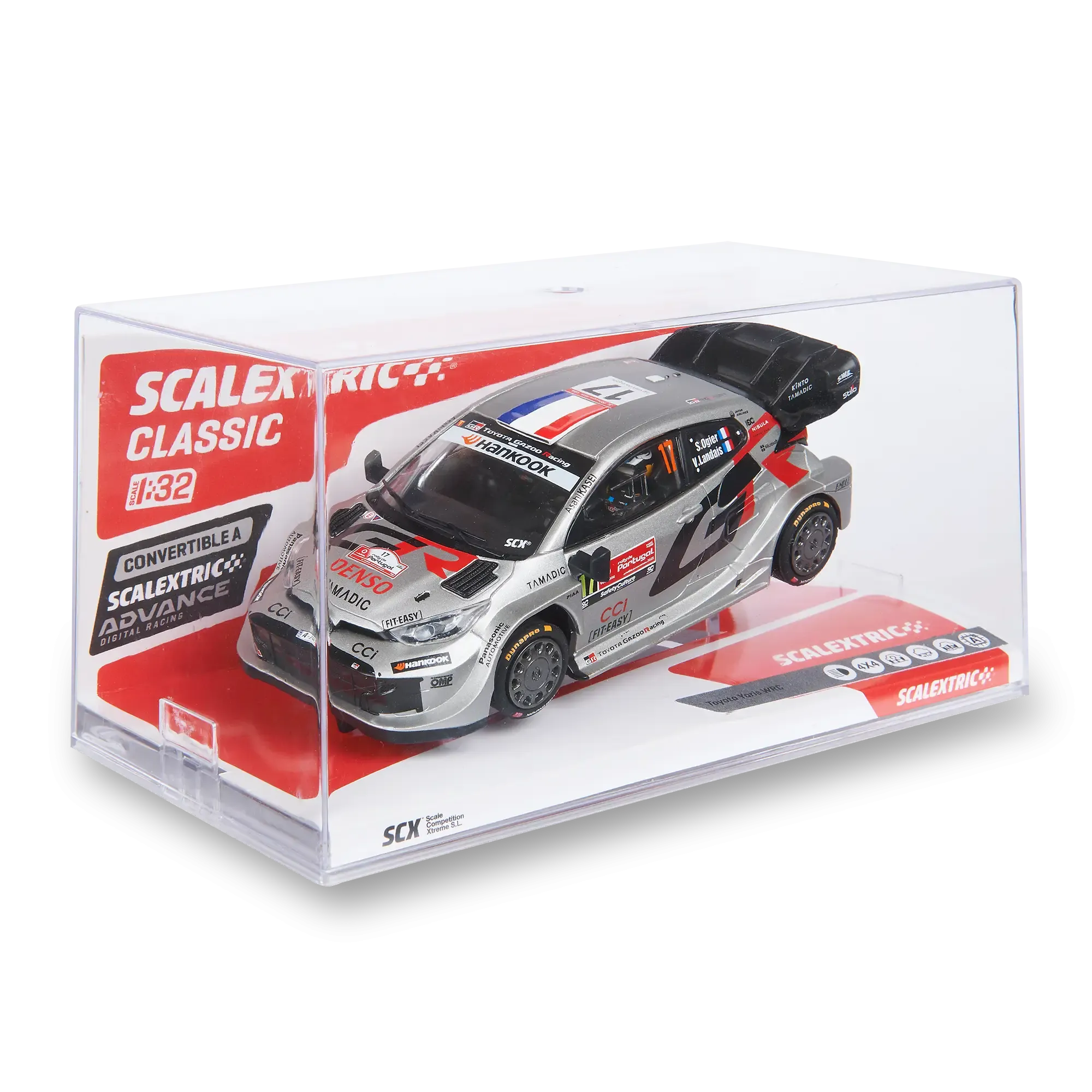 Un modelo a escala 1:32 de Scalextric de un Toyota Yaris WRC en una vitrina de plástico transparente con embalaje rojo y blanco.