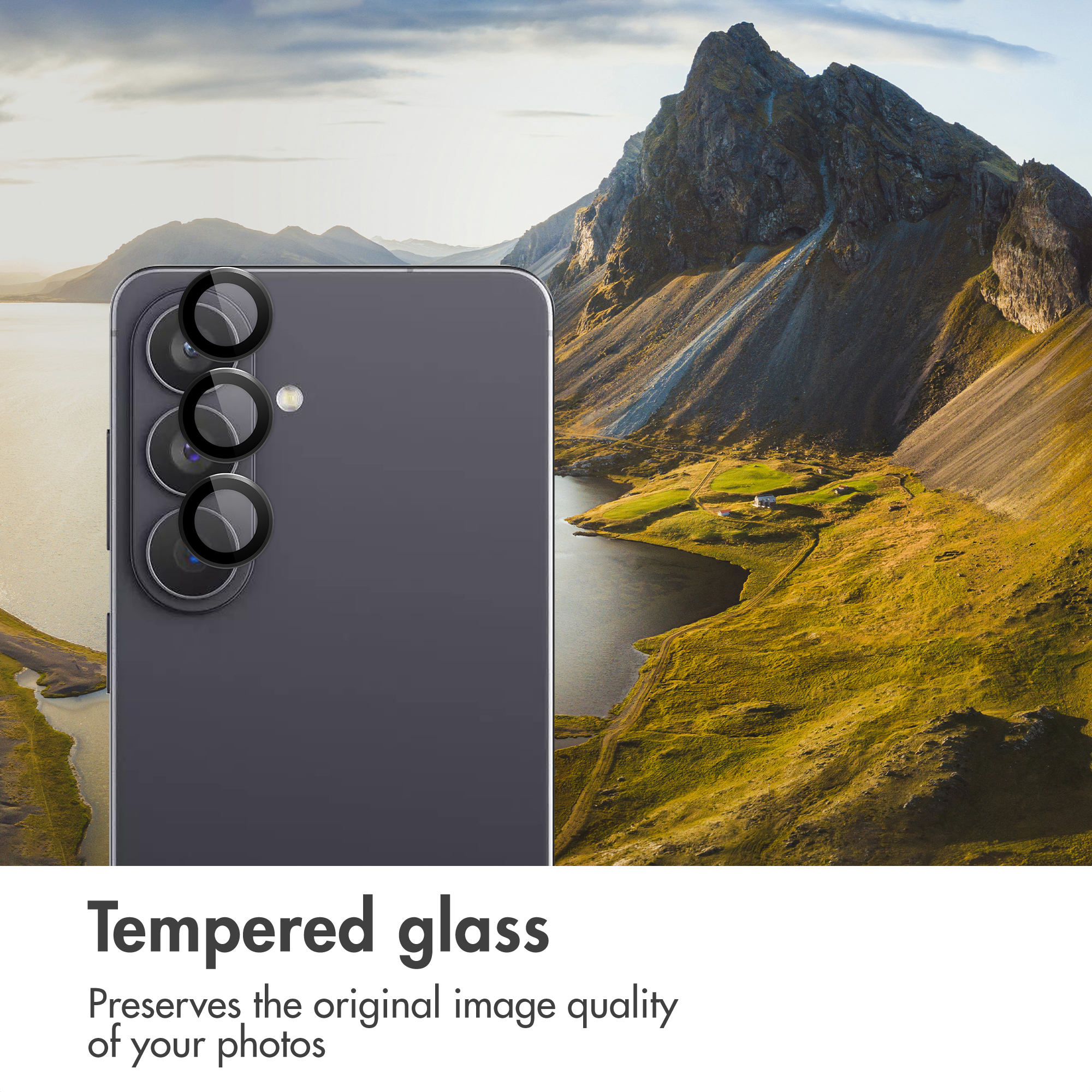 Uno smartphone con protezioni per obiettivi di fotocamera davanti a montagne e un lago.