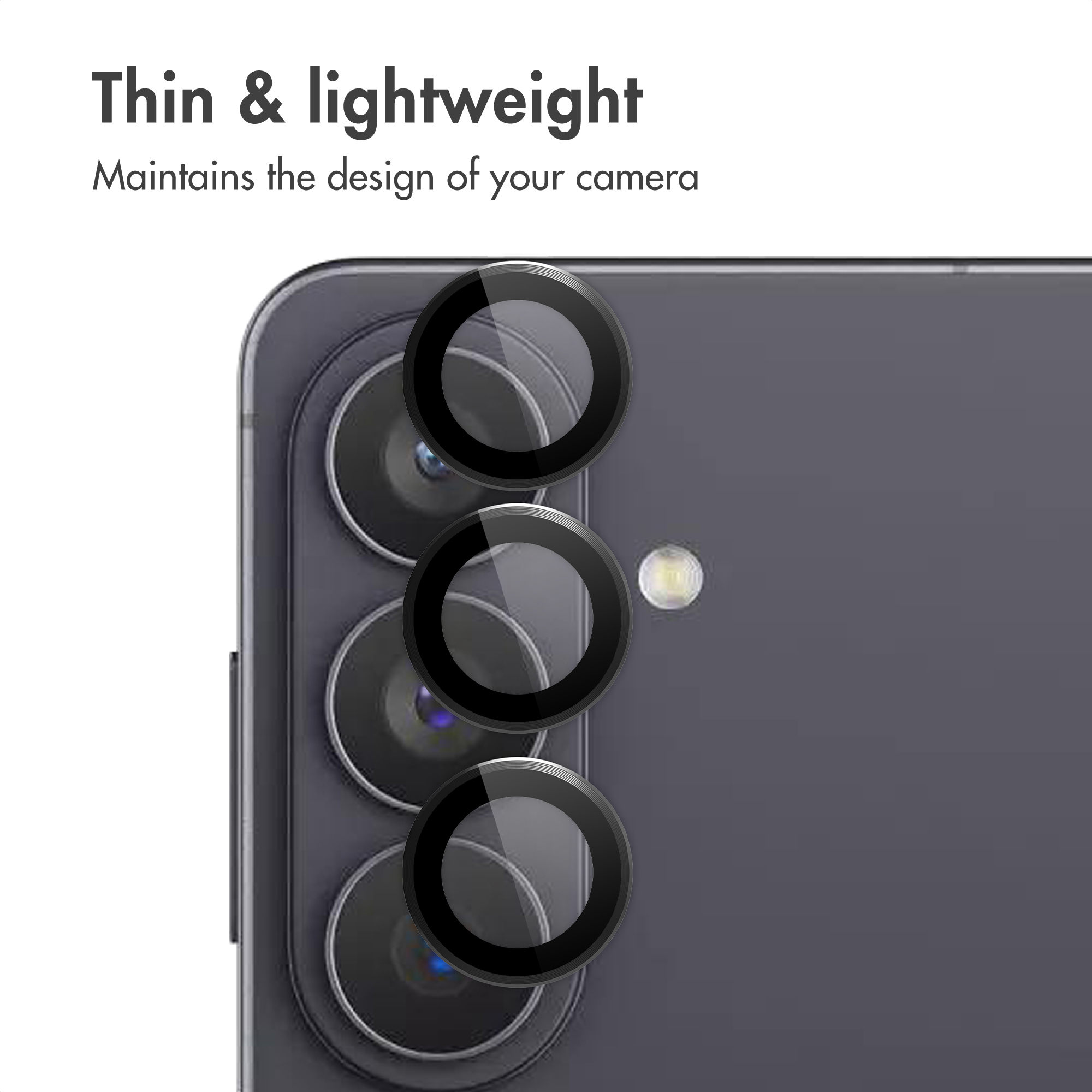 Tre anelli protettivi neri per obiettivi di fotocamera su uno smartphone grigio.