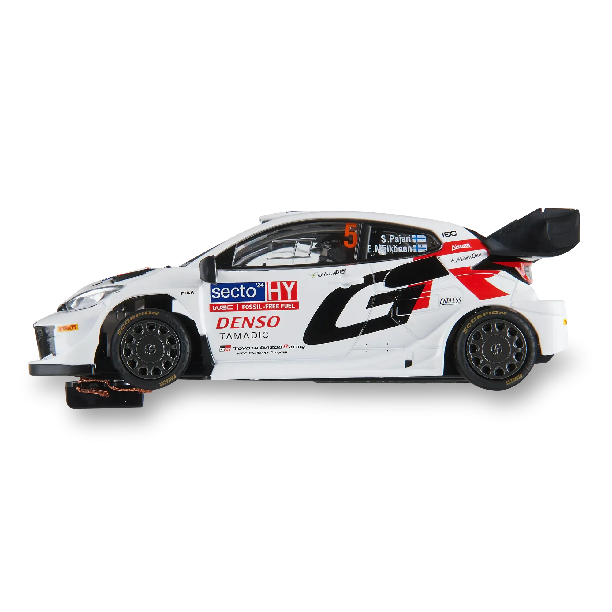 Un coche de rally de juguete blanco con calcomanías de patrocinadores negras y rojas sobre fondo negro.