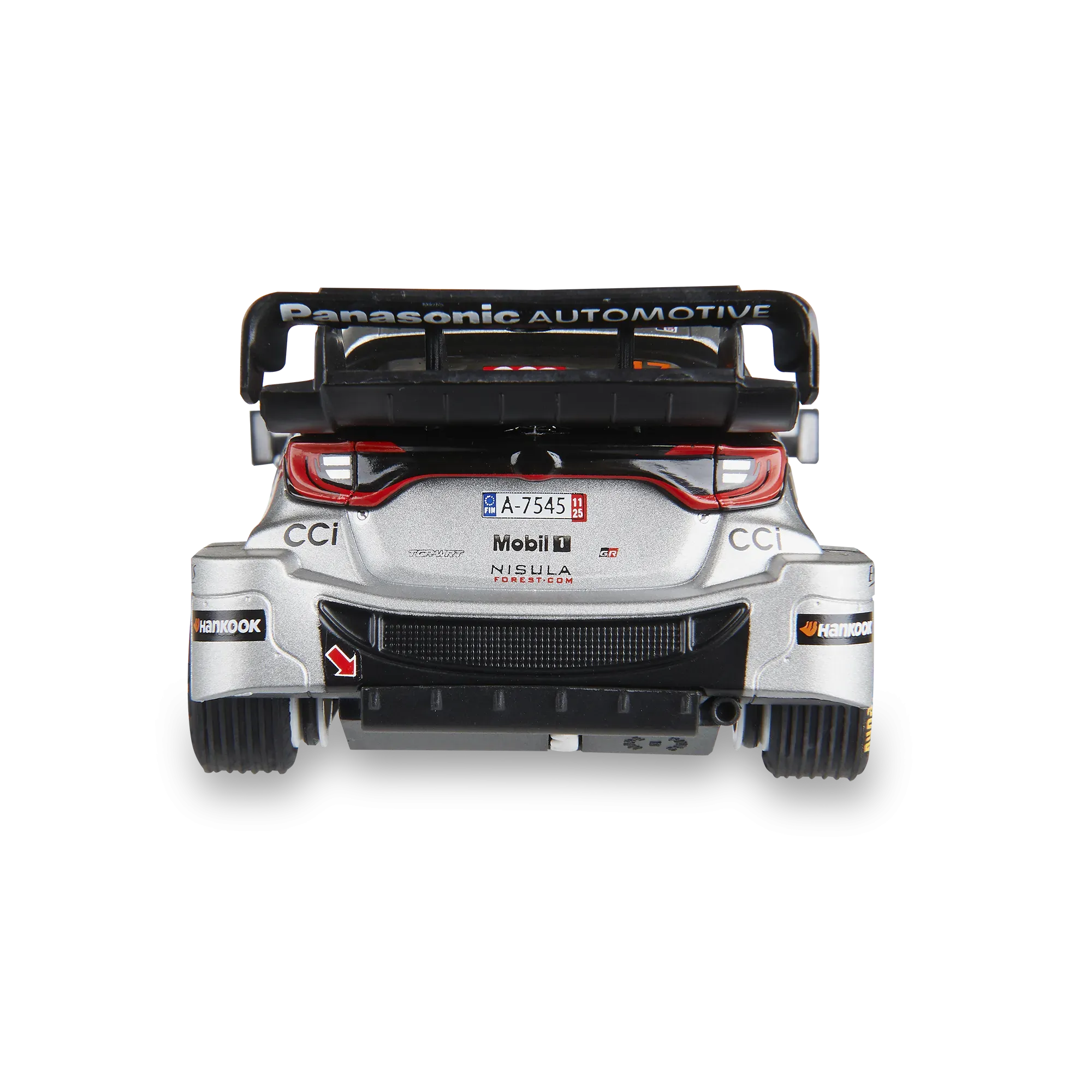 Vista trasera de un coche de rally en miniatura plateado con un alerón grande y pegatinas de patrocinadores.