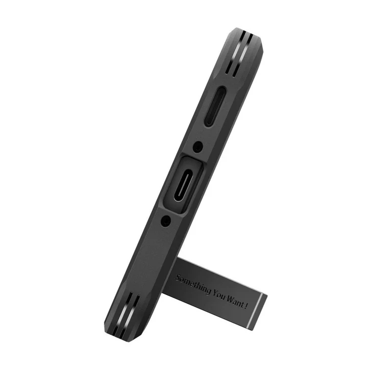 Gadget noir avec port USB-C, debout sur un support pliable avec l'inscription Something You Want!.