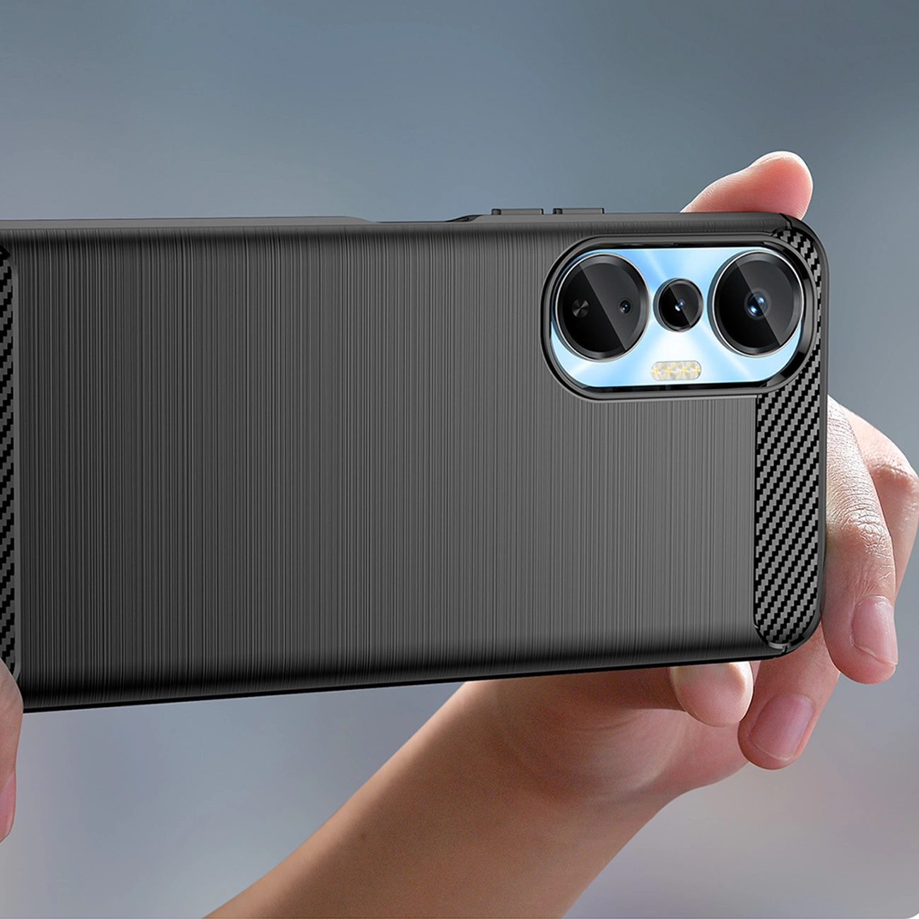 Una mano tiene uno smartphone nero con finitura in metallo spazzolato e tripla fotocamera.