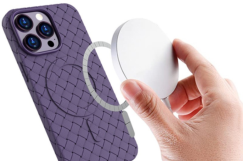 Una mano tiene un caricatore magnetico vicino a una cover viola con texture intrecciata.