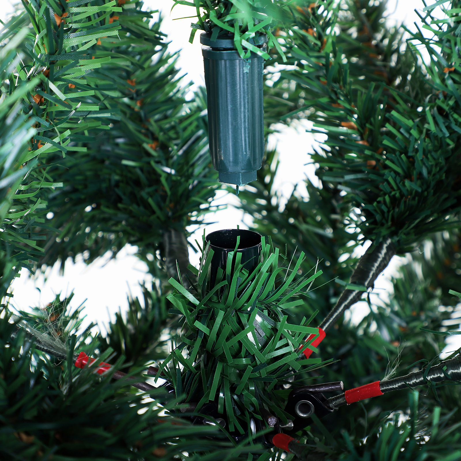 Conexión de dos secciones de un árbol de Navidad artificial con ramas verdes.