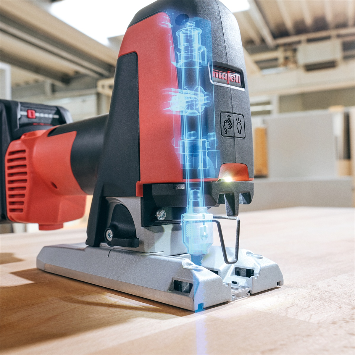 Rote und schwarze Stichsäge auf Holz mit blauer X-Ray-Grafik der Innenmechanik.