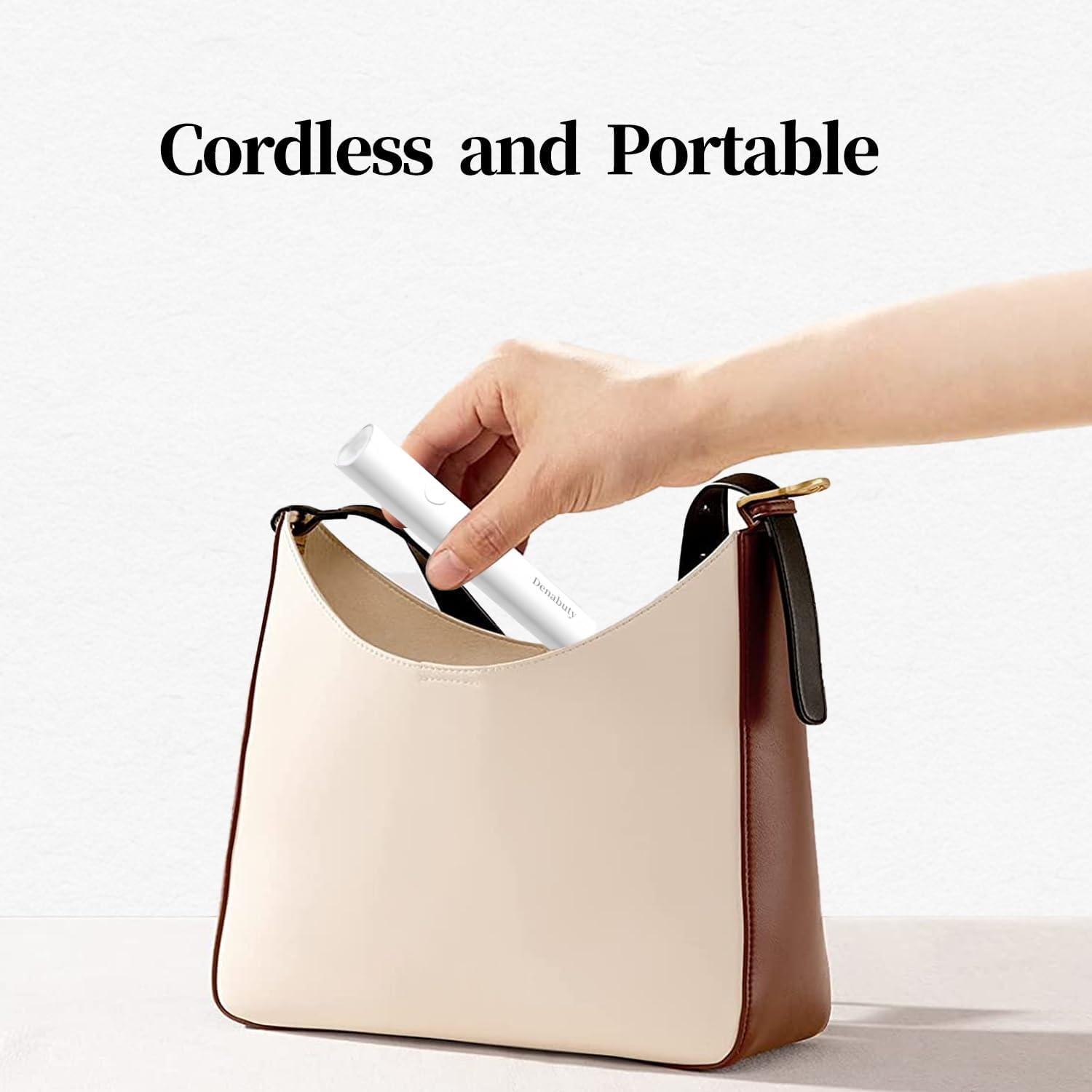 Eine Hand legt ein weißes kabelloses Gerät in eine beige-braune Handtasche vor weißem Hintergrund.