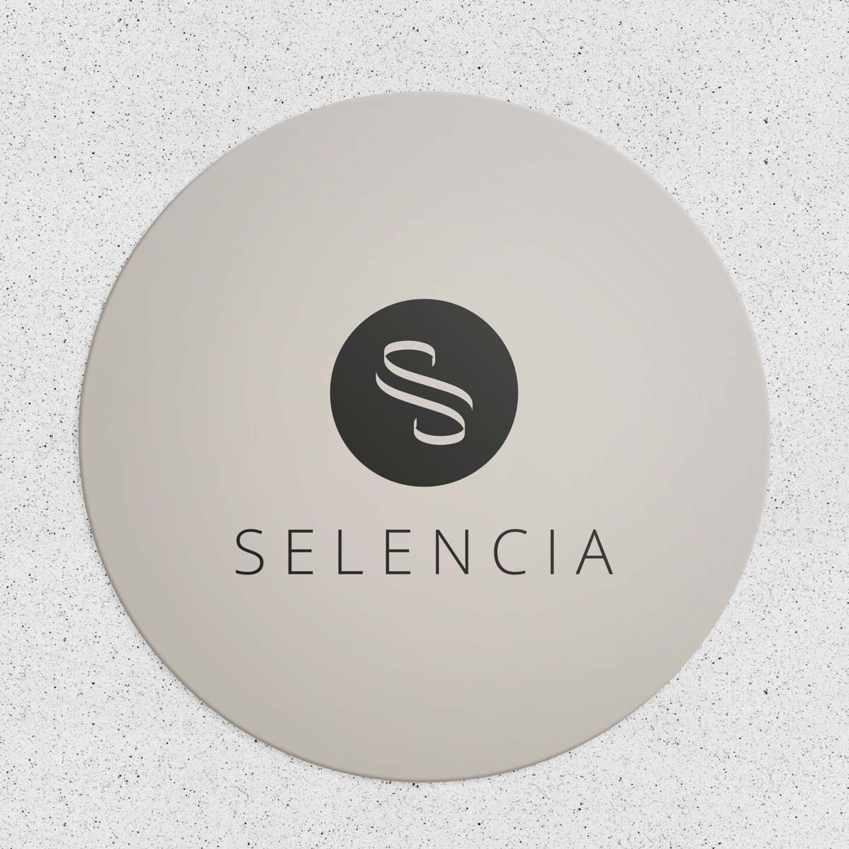 Un letrero circular beige con el texto negro SELENCIA y un logotipo redondo arriba.