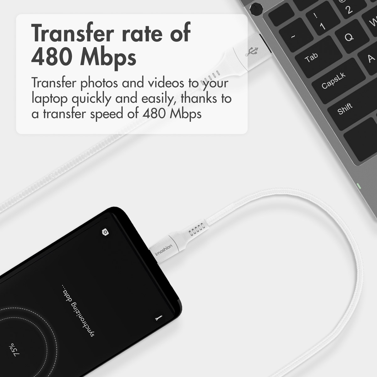 Câble USB blanc reliant un smartphone à un ordinateur portable.