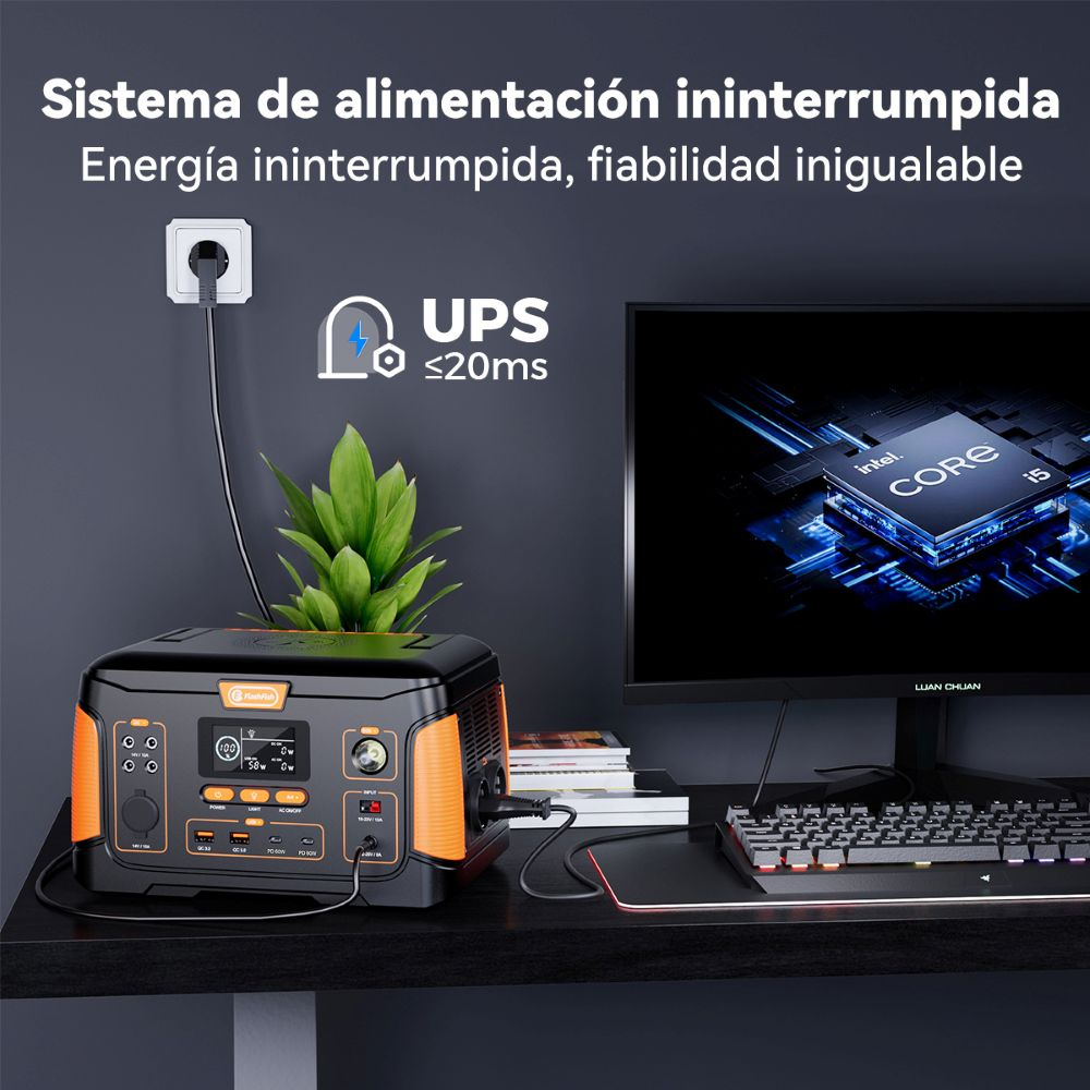 Estación de energía portátil en un escritorio con PC, conectada a un enchufe y monitor para suministro ininterrumpido.