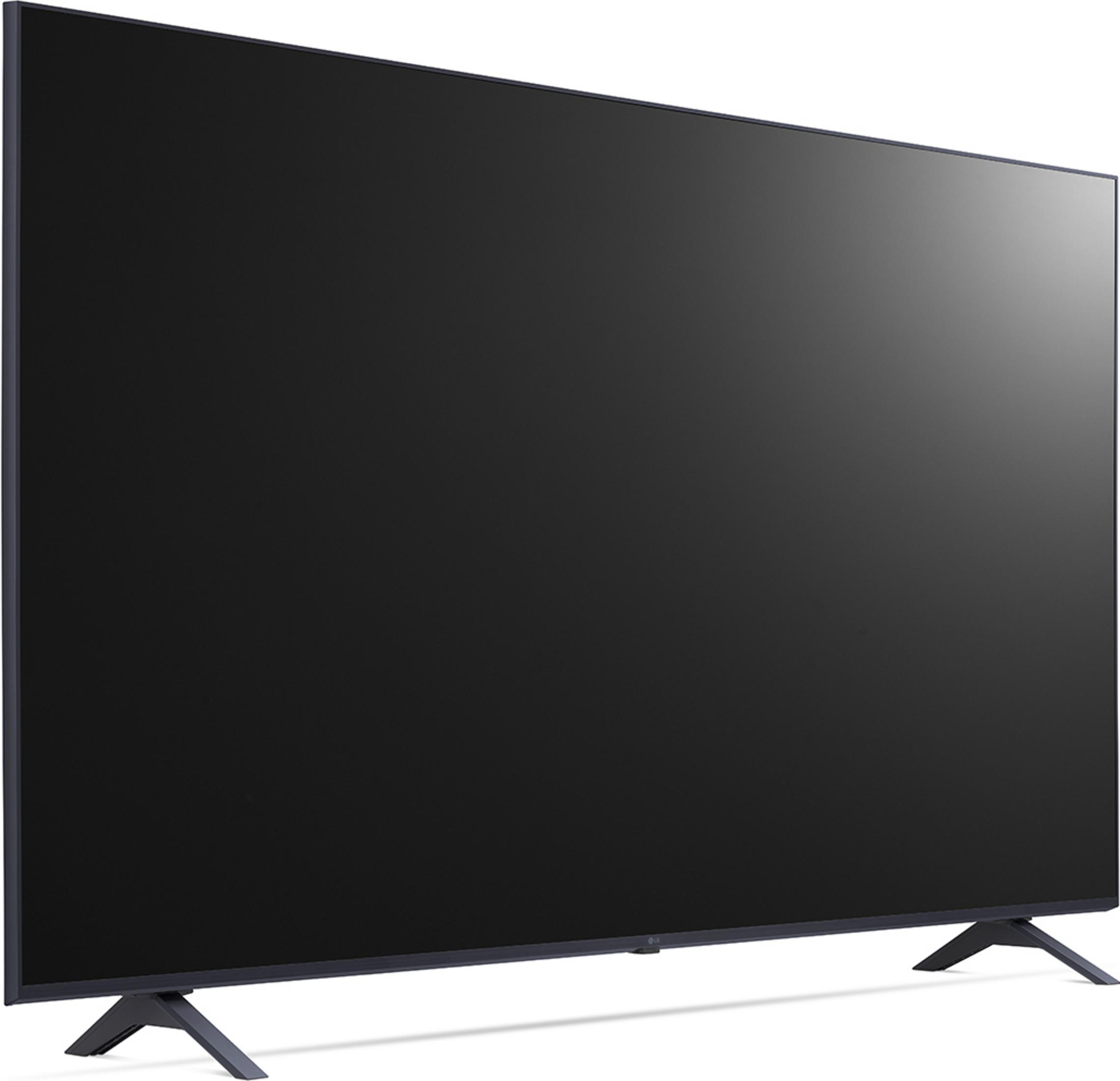 Una TV a schermo piatto nera poggia su due piccoli supporti su una superficie bianca con sfondo chiaro.