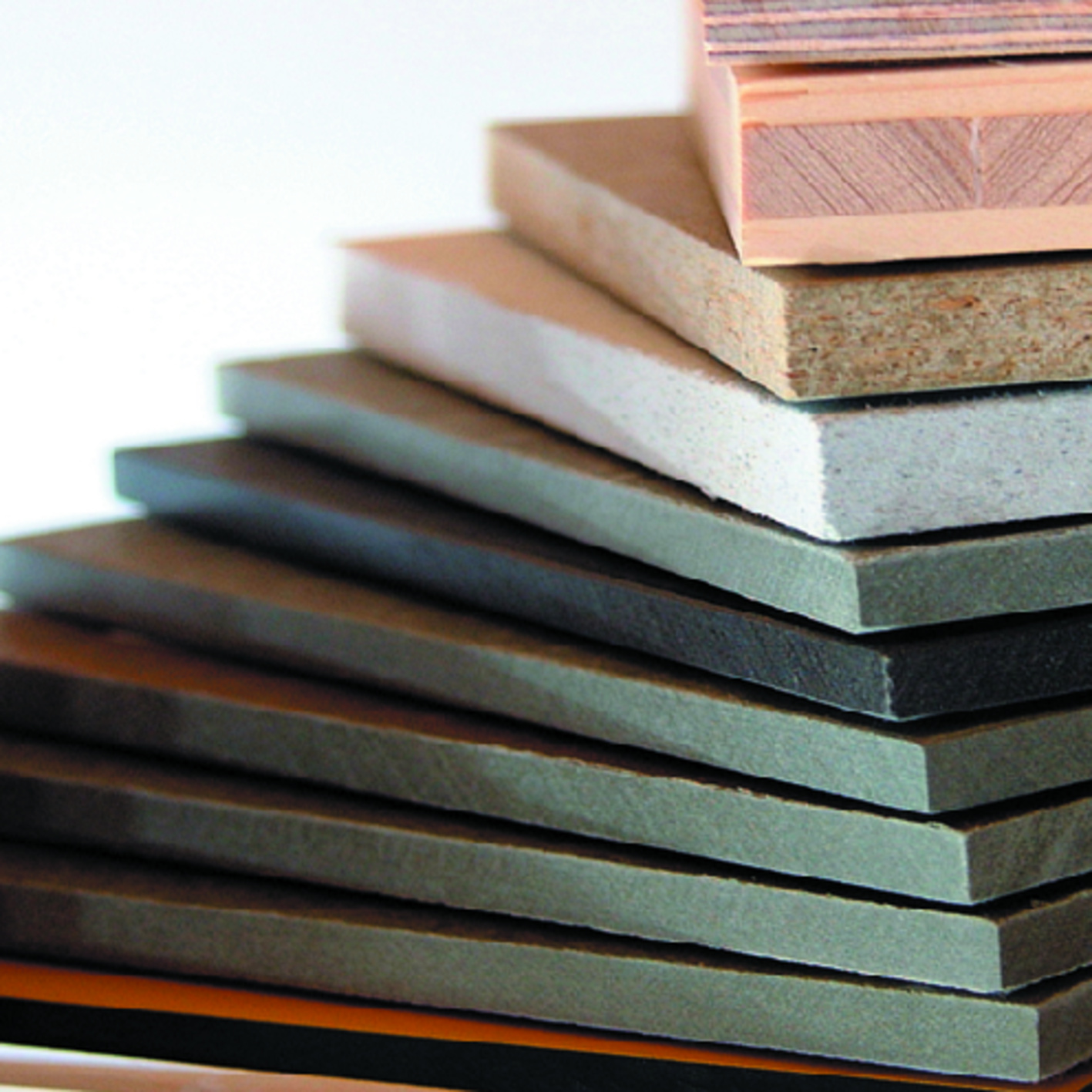 Ein Stapel verschiedener Holz- und Verbundplatten mit unterschiedlichen Texturen und Farben.