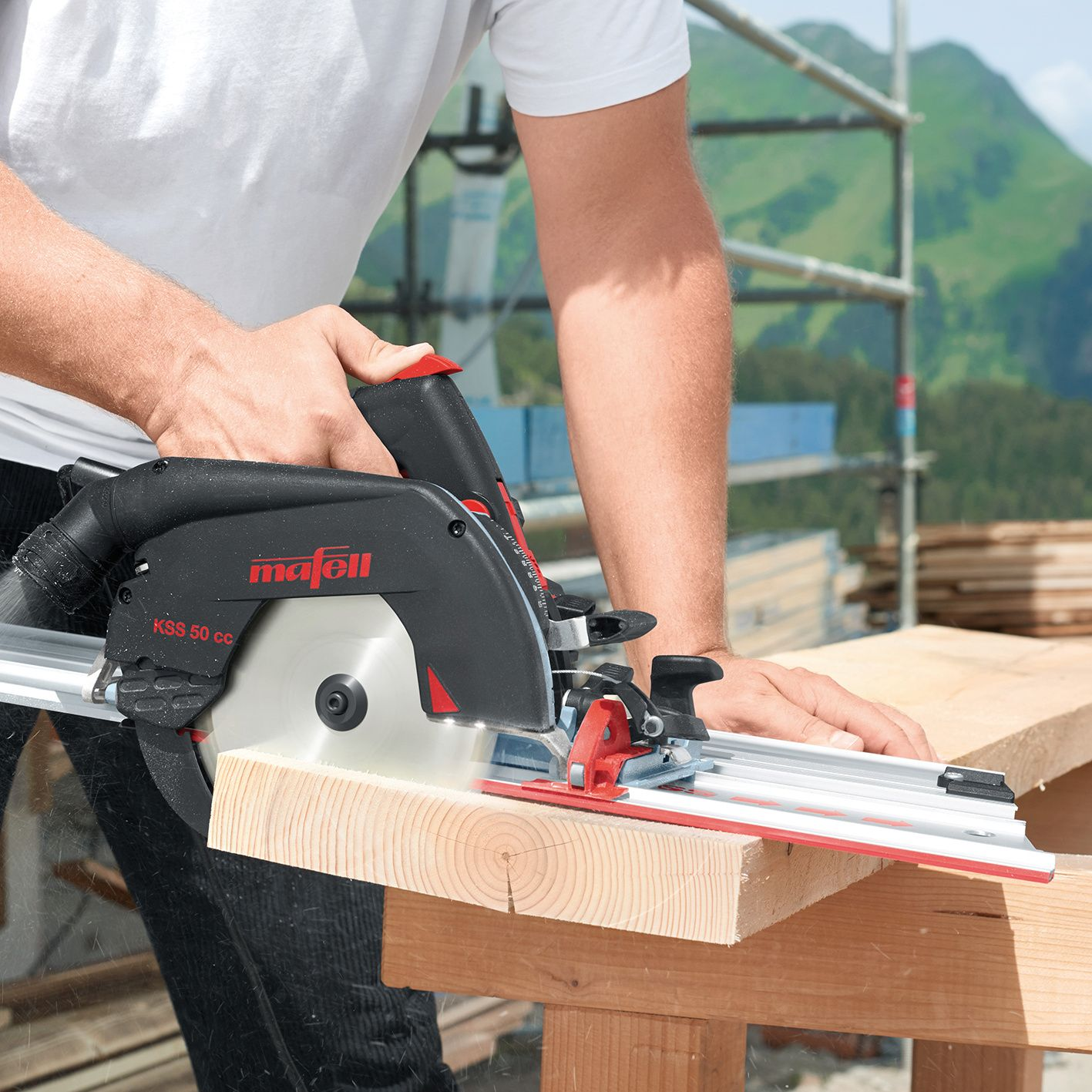 Ein Handwerker schneidet einen Holzbalken mit einer schwarzen Mafell Handkreissäge auf einer Führungsschiene.