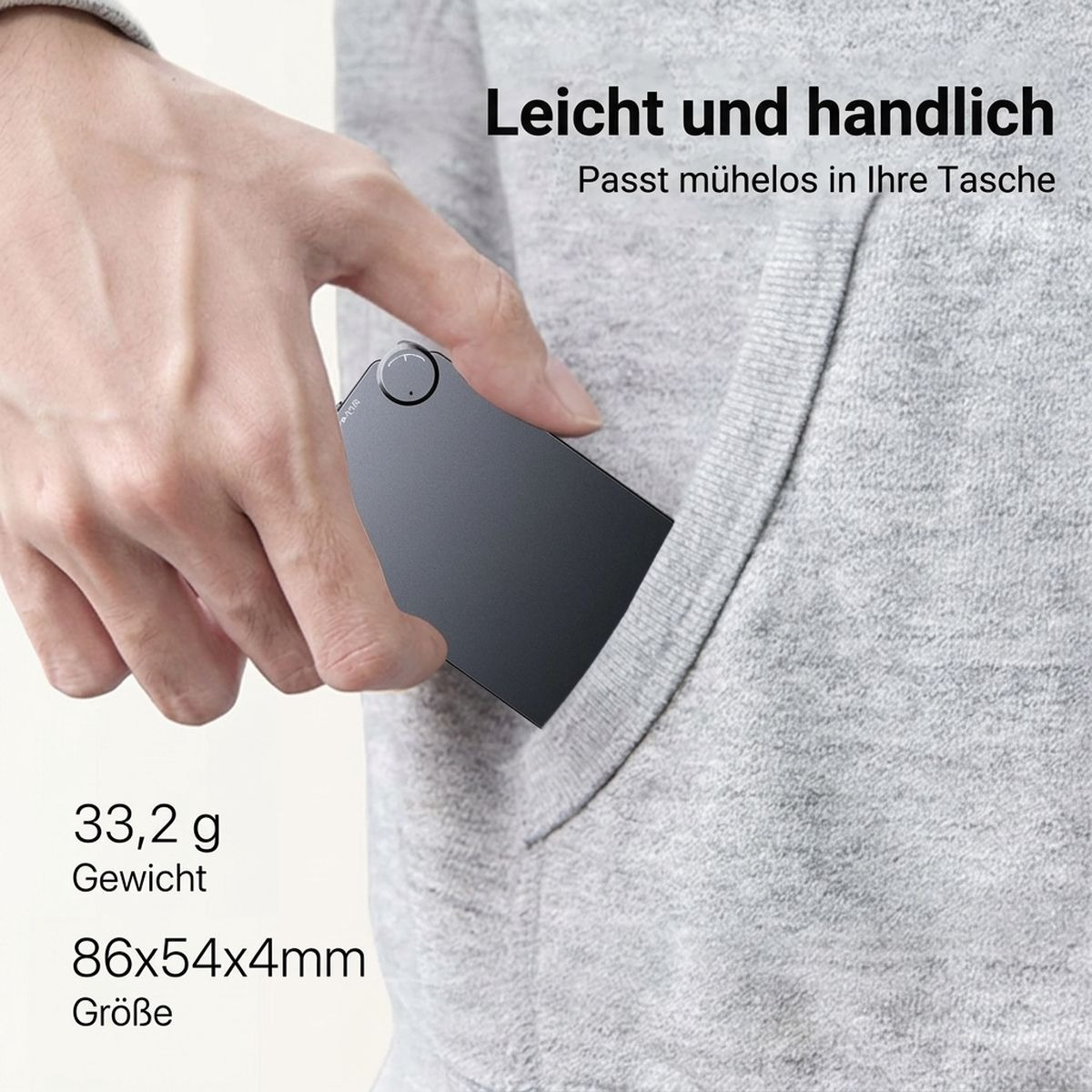 Eine Hand schiebt ein kleines, graues Gerät in die Tasche eines grauen Hoodies.