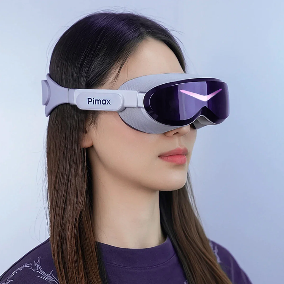 Una mujer con gafas de realidad virtual Pimax grises y lentes moradas sobre fondo azul claro.