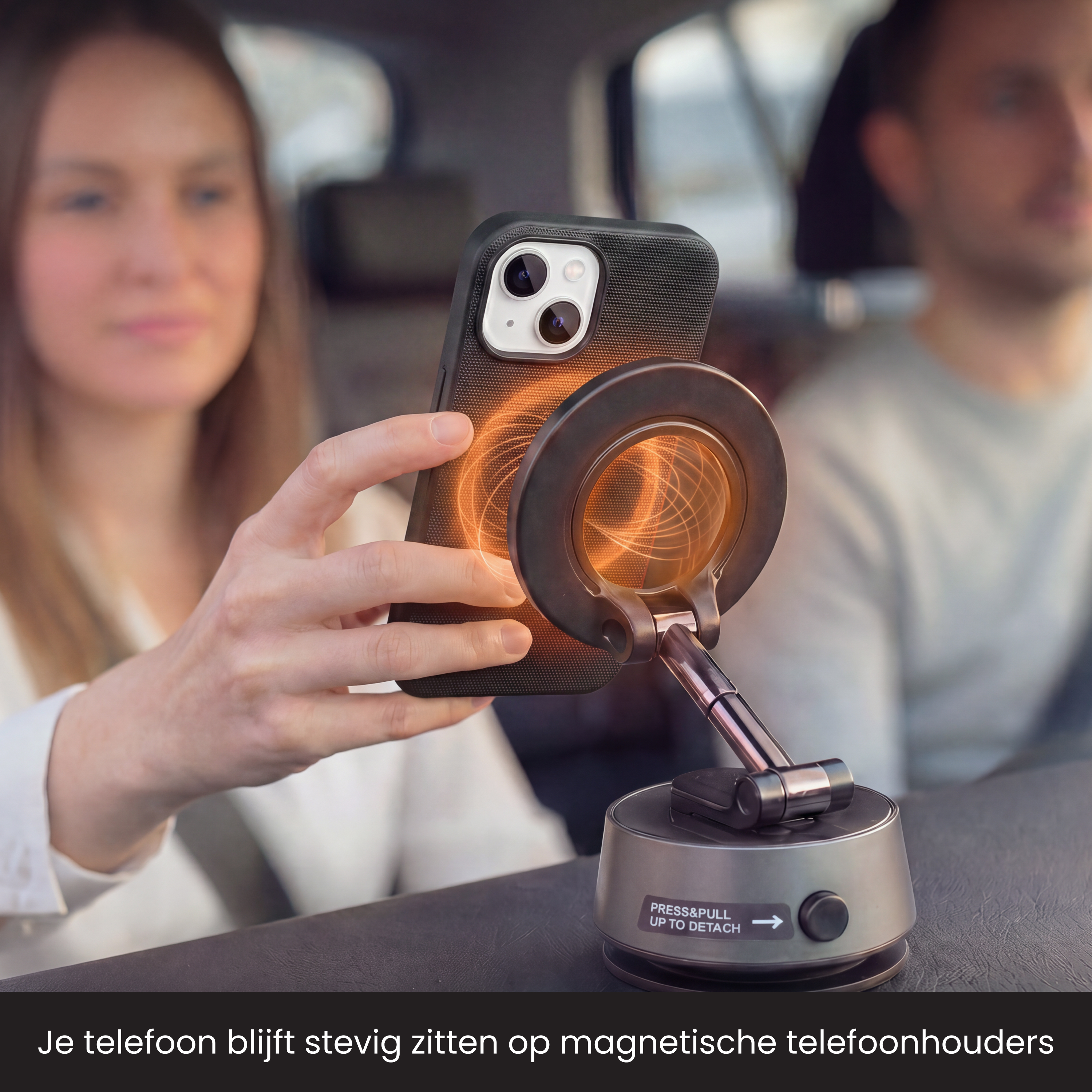 Een vrouw houdt een smartphone vast die magnetisch op een autohouder met oranje magnetische lijnen zit.
