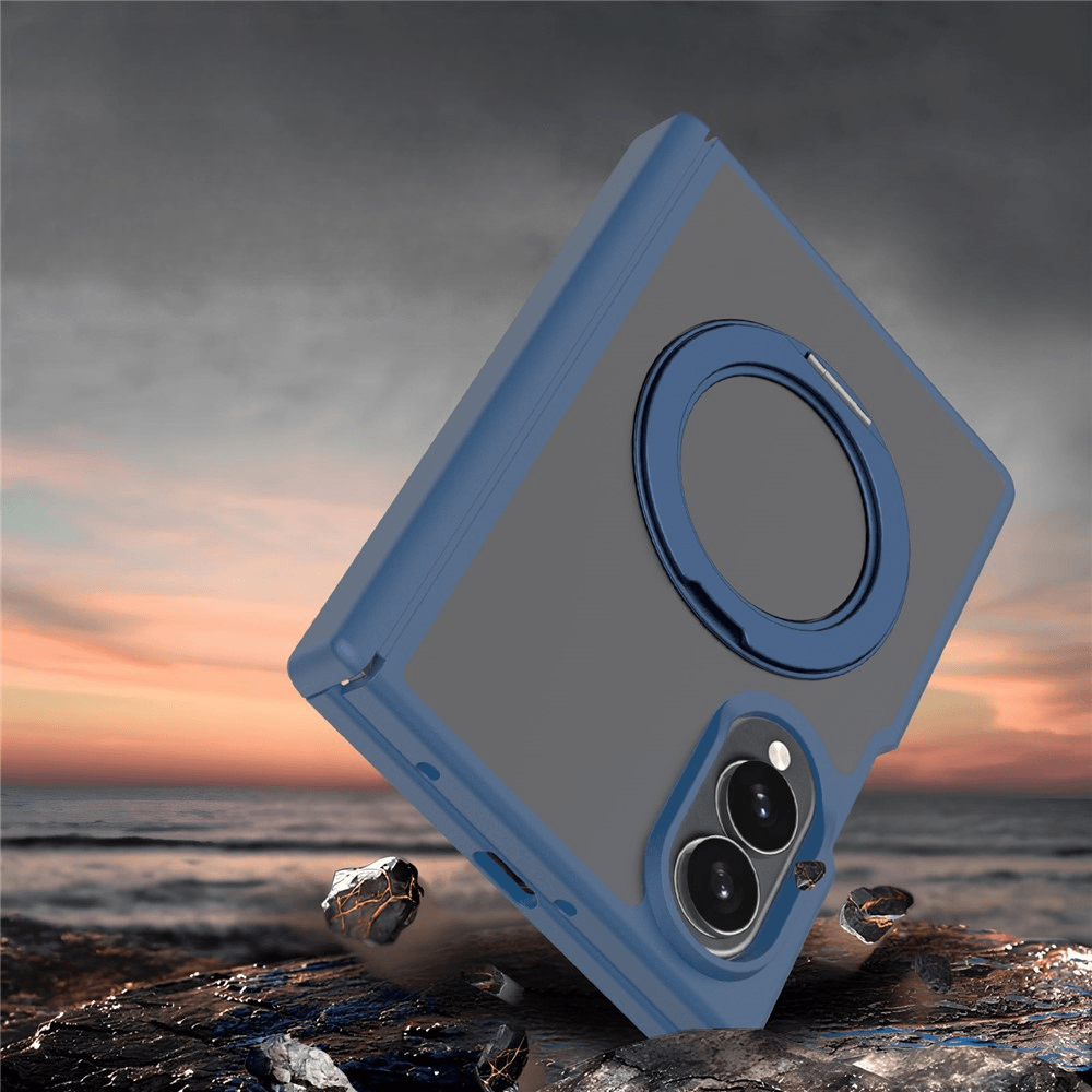 Ein blaues Smartphone in robuster Hülle schwebt über felsigem Boden vor einem Meer und abendlichem Himmel.