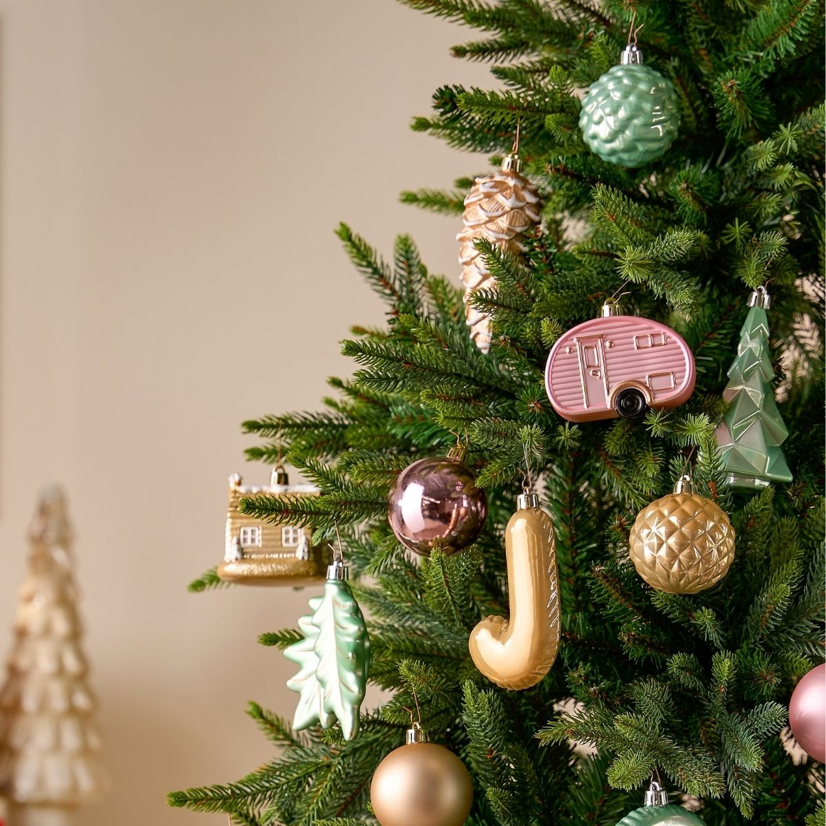 Sapin de Noël décoré d'ornements colorés aux tons pastel.