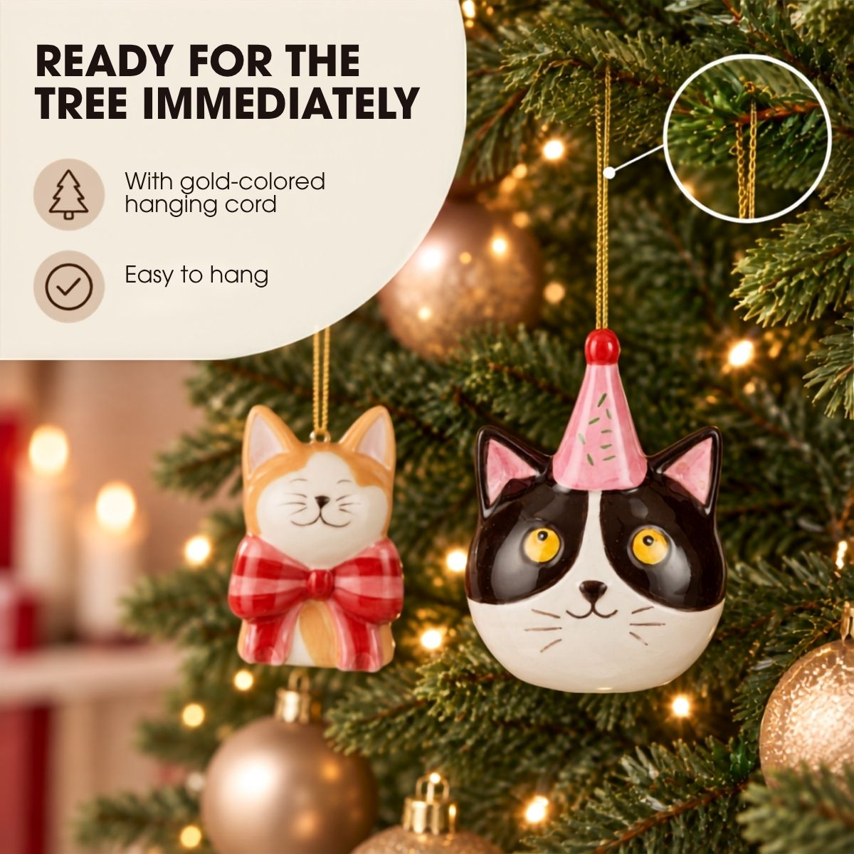 Deux décorations de Noël de chat en céramique pendent sur un arbre illuminé de manière festive.