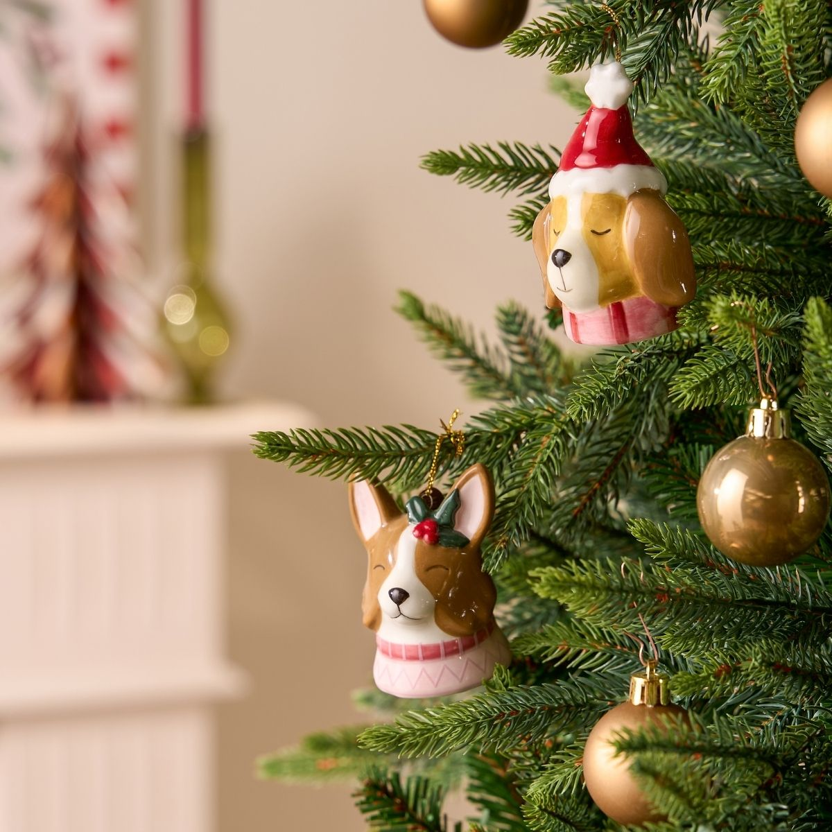 Un sapin de Noël décoré d'ornements de chiens, dont un Corgi en pull et un chien en bonnet de Père Noël.